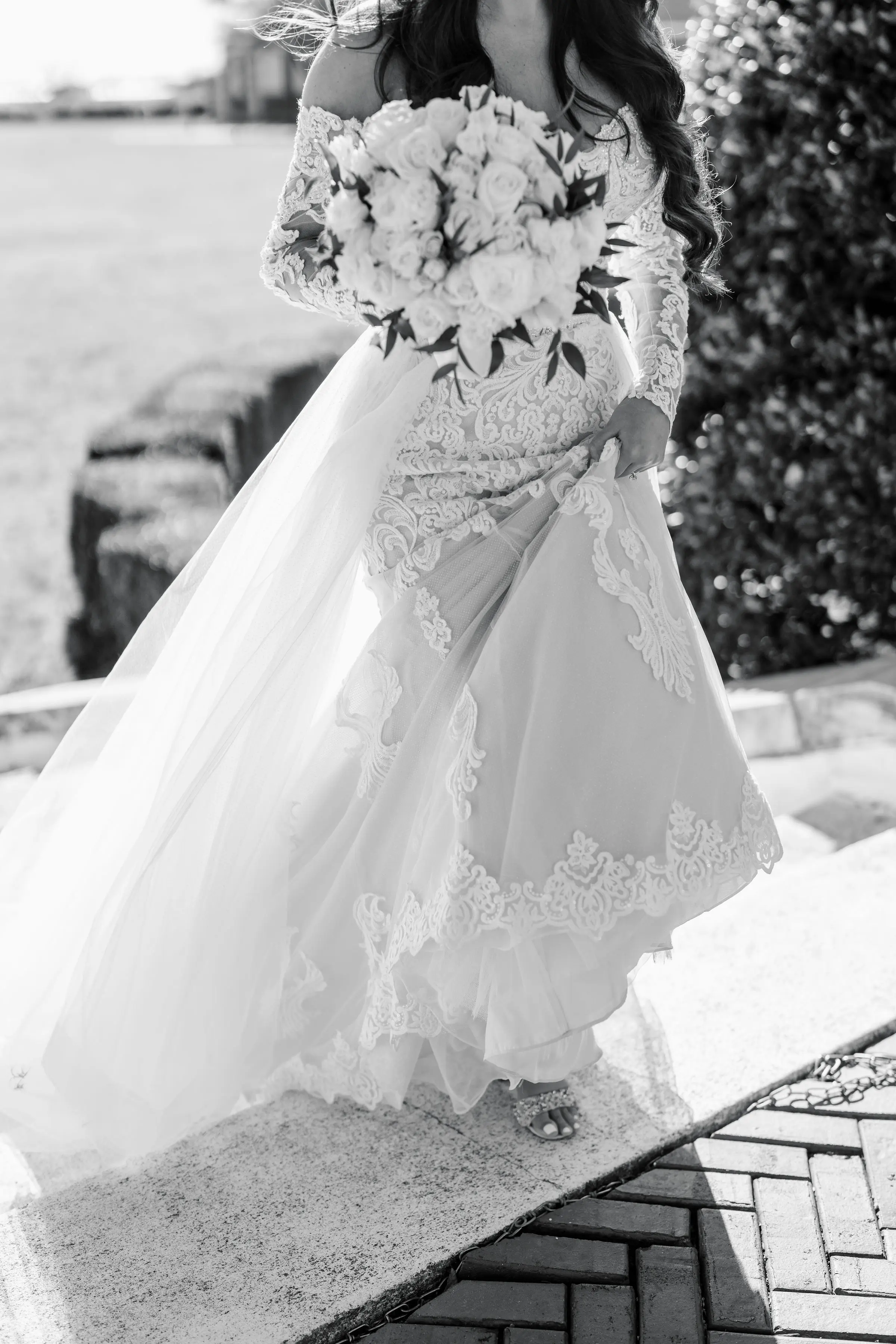 Bride Wearing Sparkly Lace Fit-and-Flare Wedding Dress Walking Upstairs Outdoors.