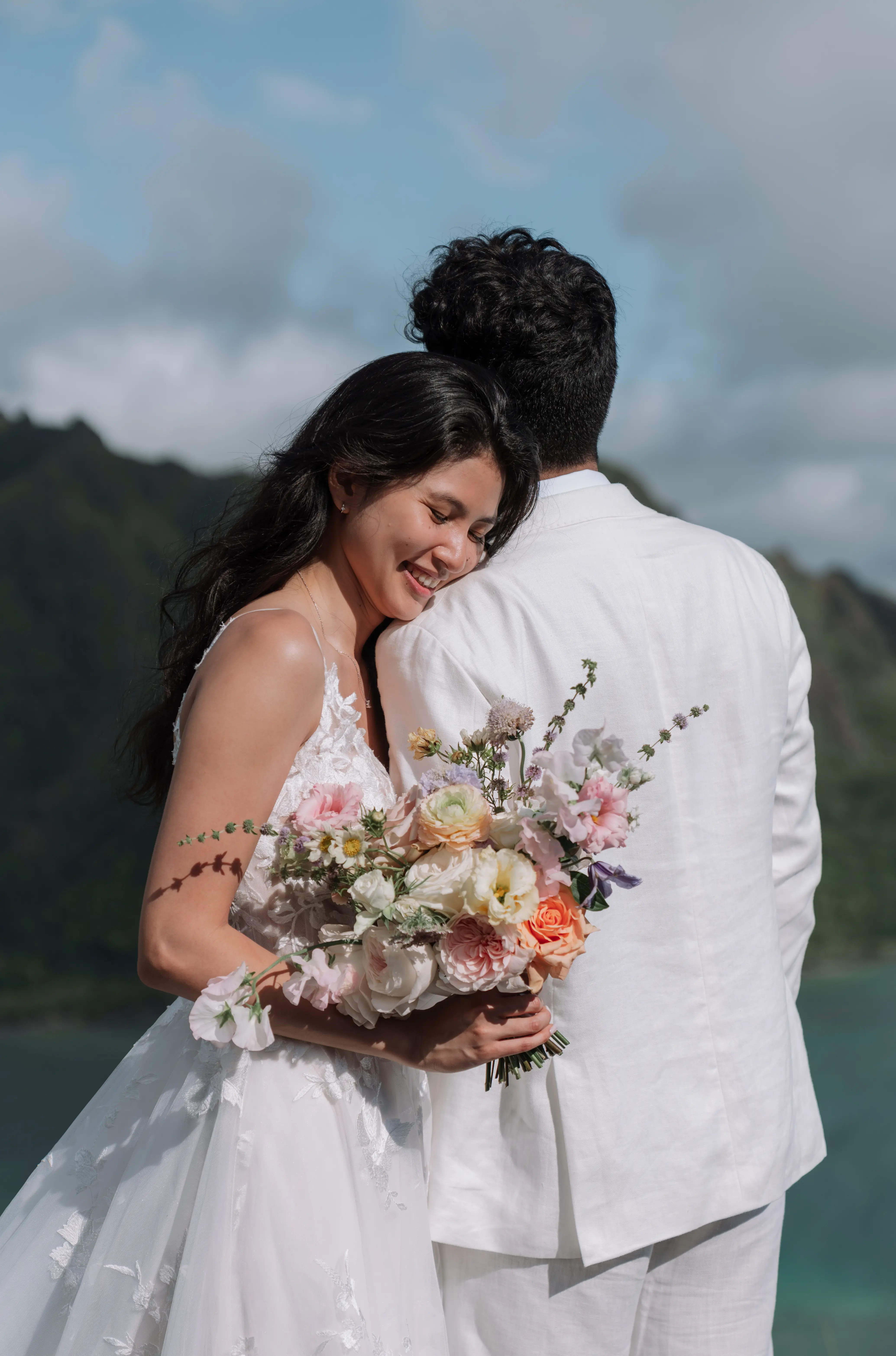 Bride wearing Winter by Maggie Sottero leaning her head on her husband's shoulder