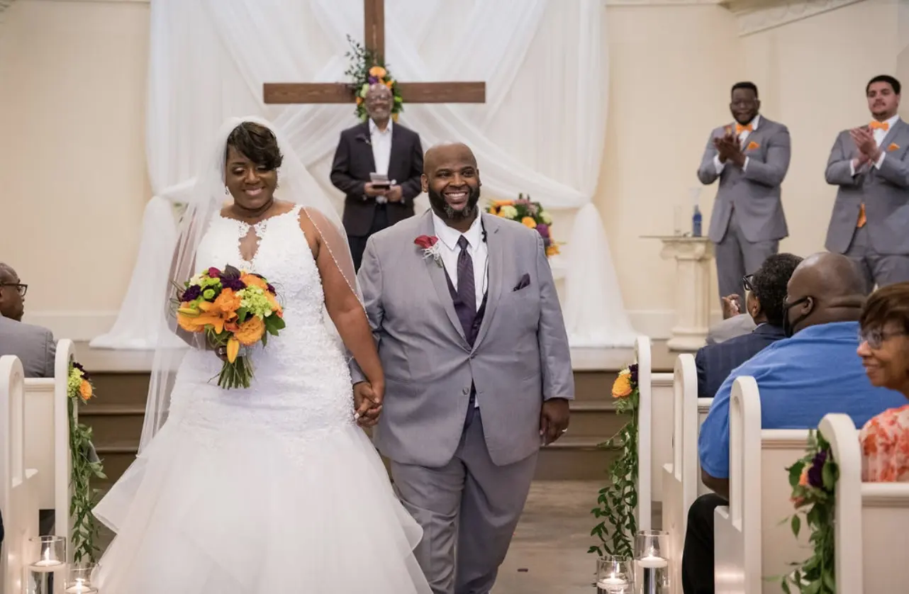 Bride and groom leaving the altar hand in hand smiling.