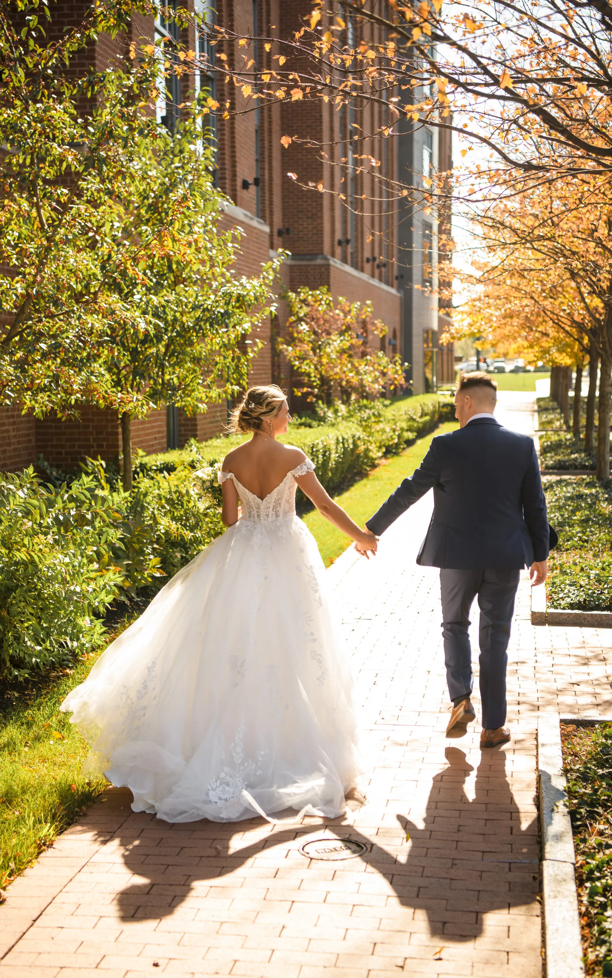 Bride wearing Harlem wedding dress by Maggie Sottero holding hands with the groom