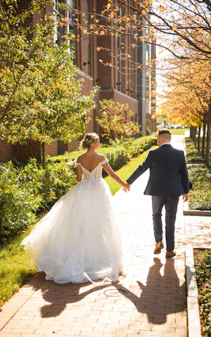 Bride wearing Harlem wedding dress by Maggie Sottero holding hands with the groom
