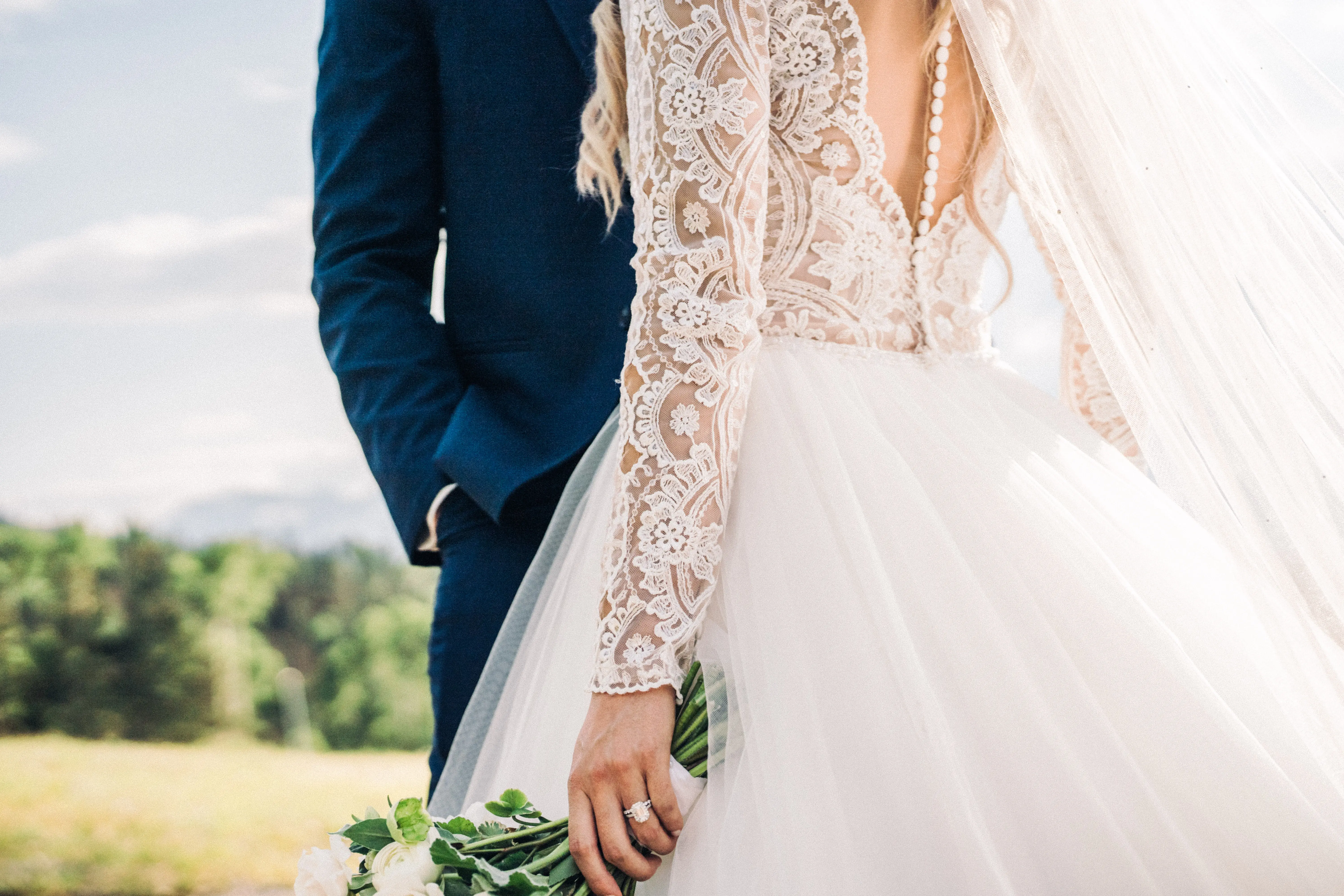 Bride with groom wearing long sleeve lace ballgown wedding dress