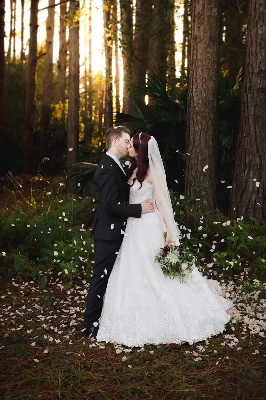Groom Kissing Bride in Lace Ball Gown Wedding Dress with Sequined Tulle and Lace Motifs over Bodice and Statement Hemline called Tristyn by Maggie Sottero