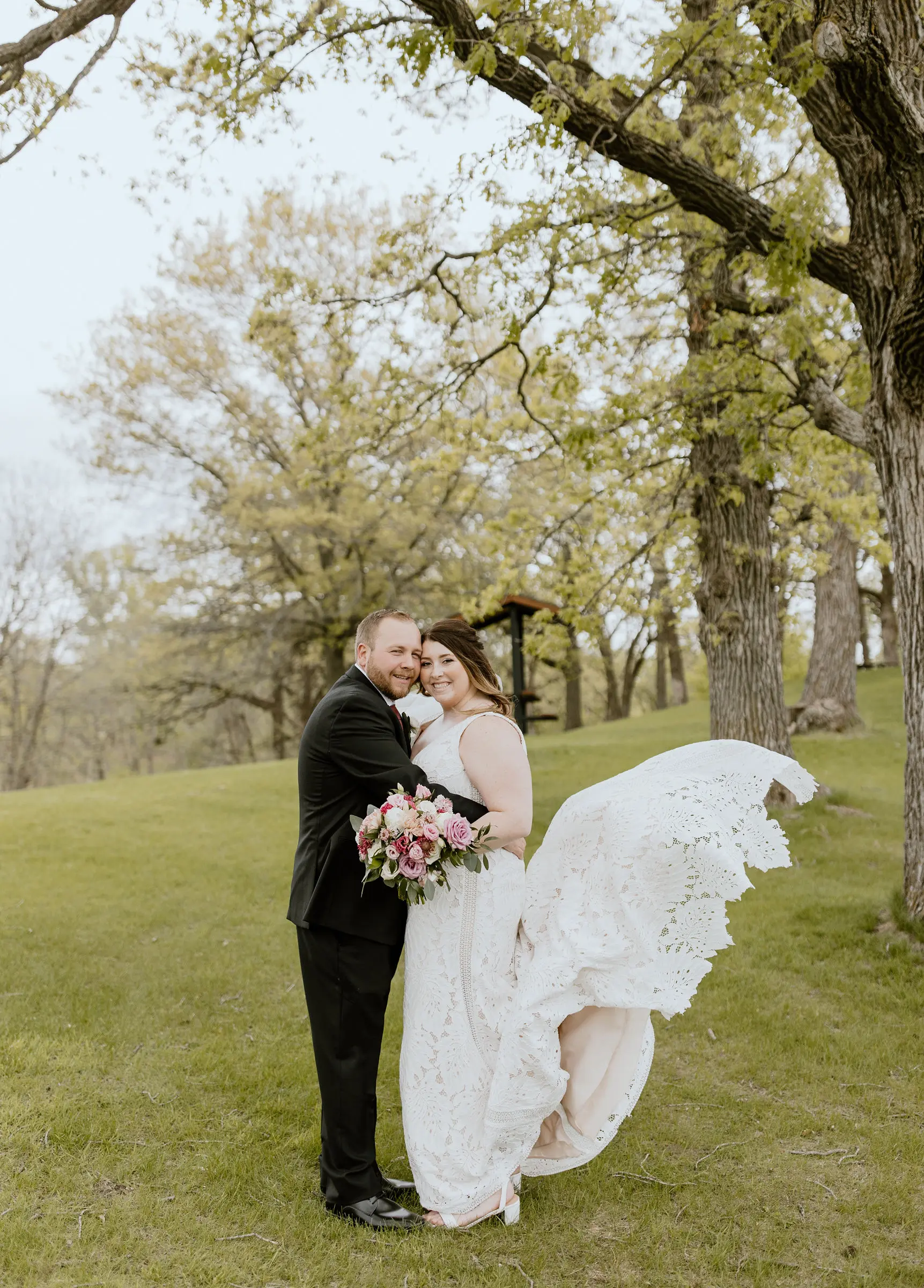 Groom Embracing Bride in Boho Lace Wedding Dress with Oversized Florals Called Burke by Maggie Sottero