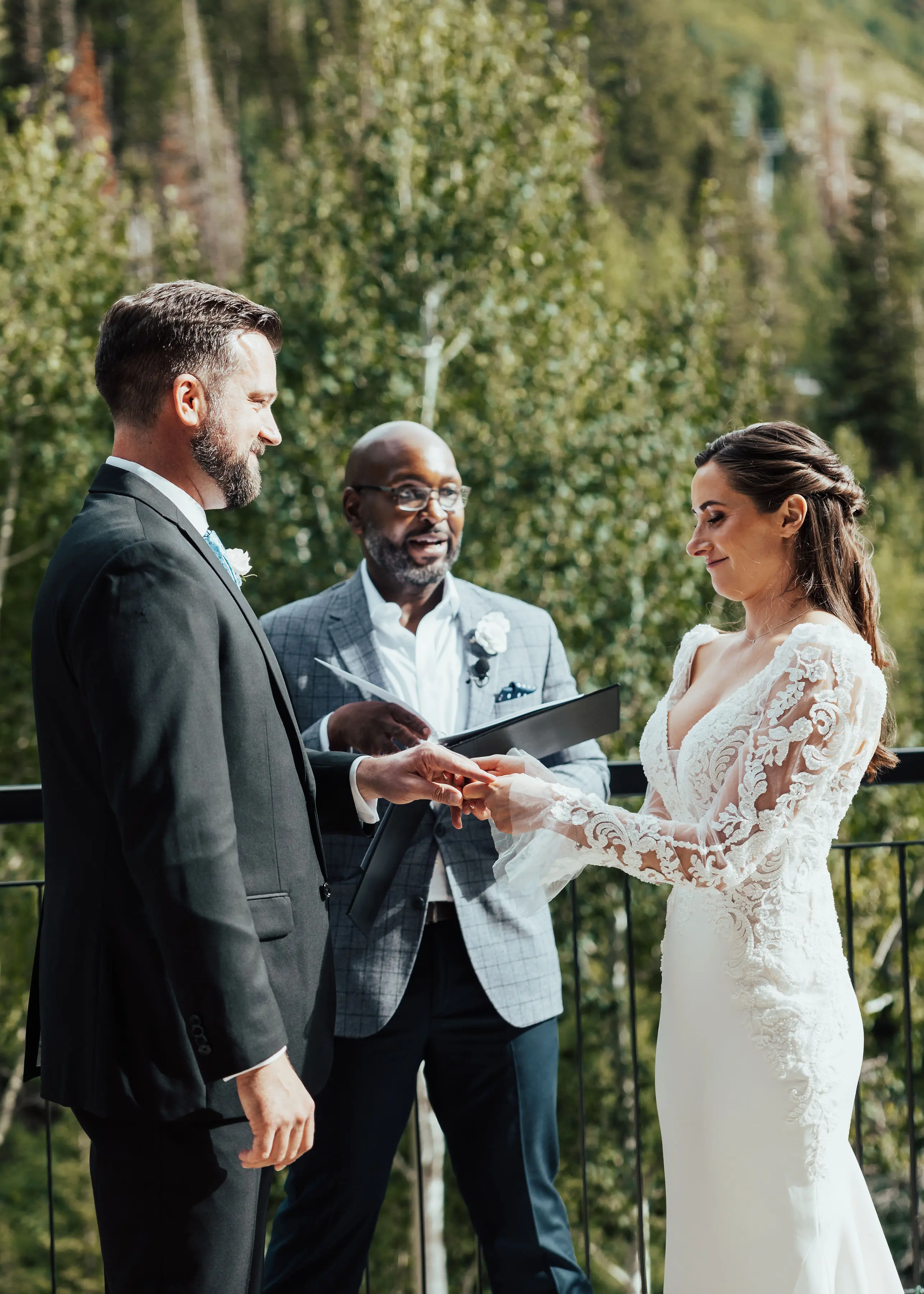 Bride Wearing Long Sleeve Lace Mermaid Wedding Dress with Groom Outdoors.