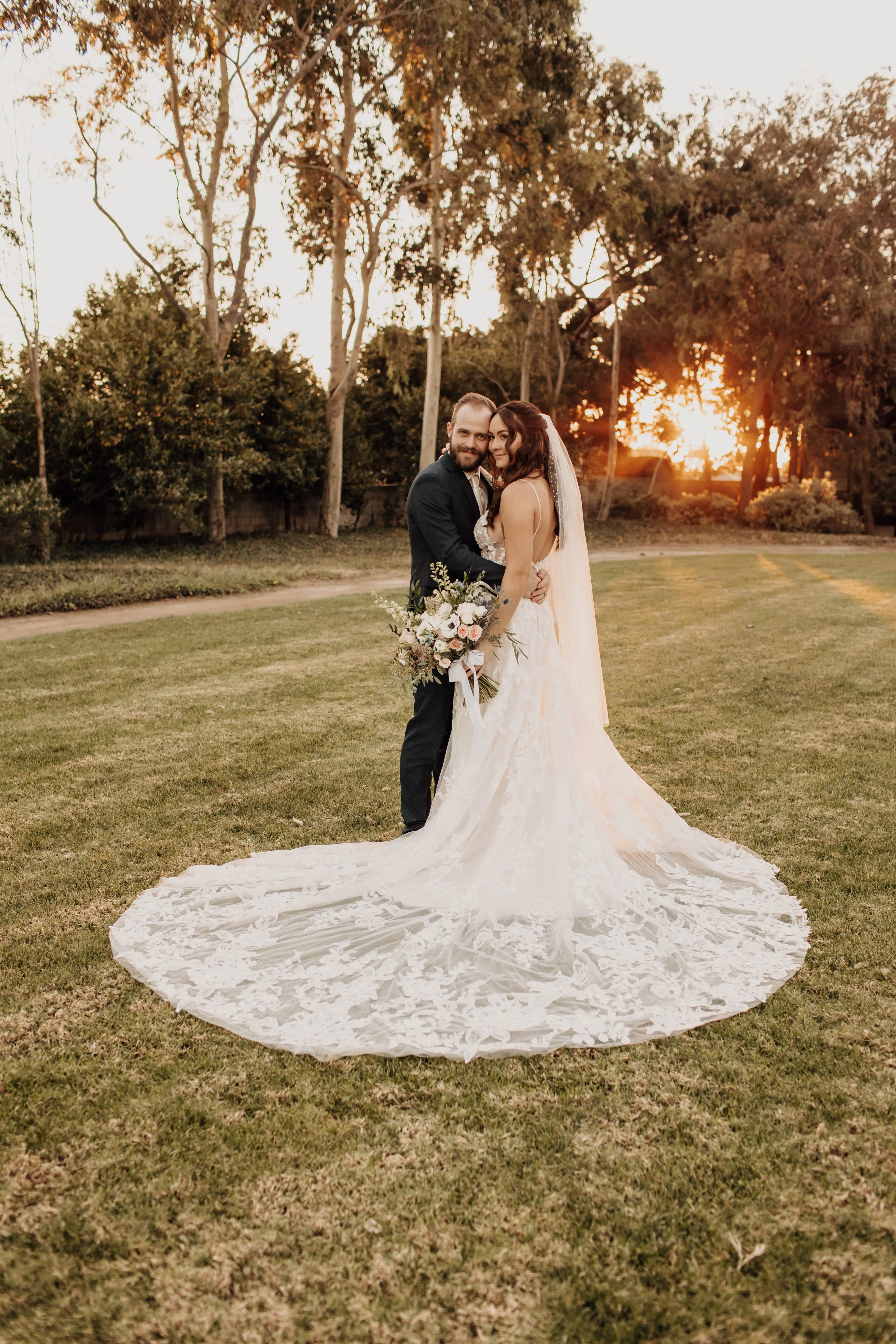 Bride wearing wedding dress called Marlow, being held by her groom.