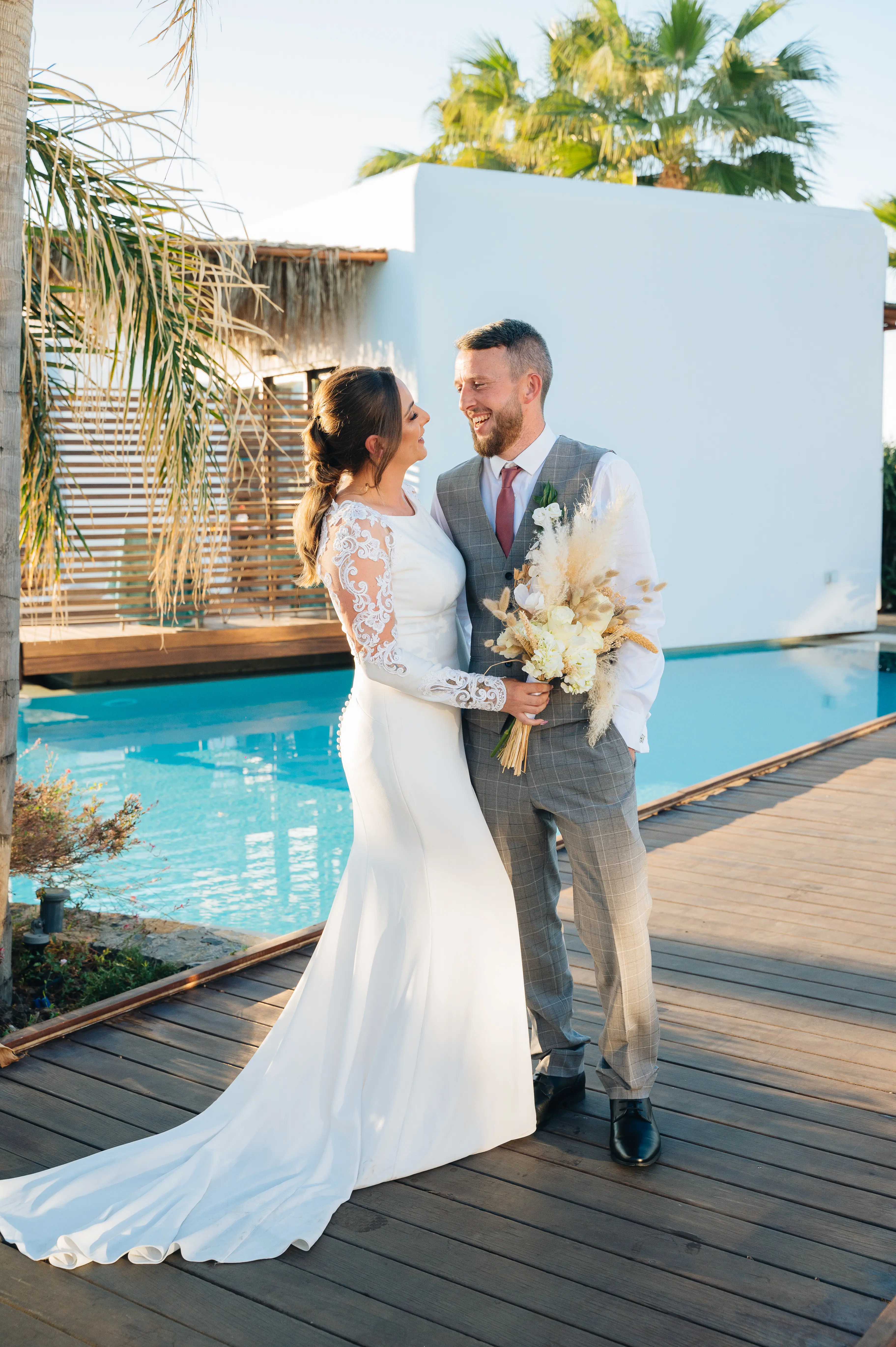 Groom with Real Bride in Minimalist Crepe Long Sleeve Lace Sheath Wedding Dress Called Bethany by Rebecca Ingram