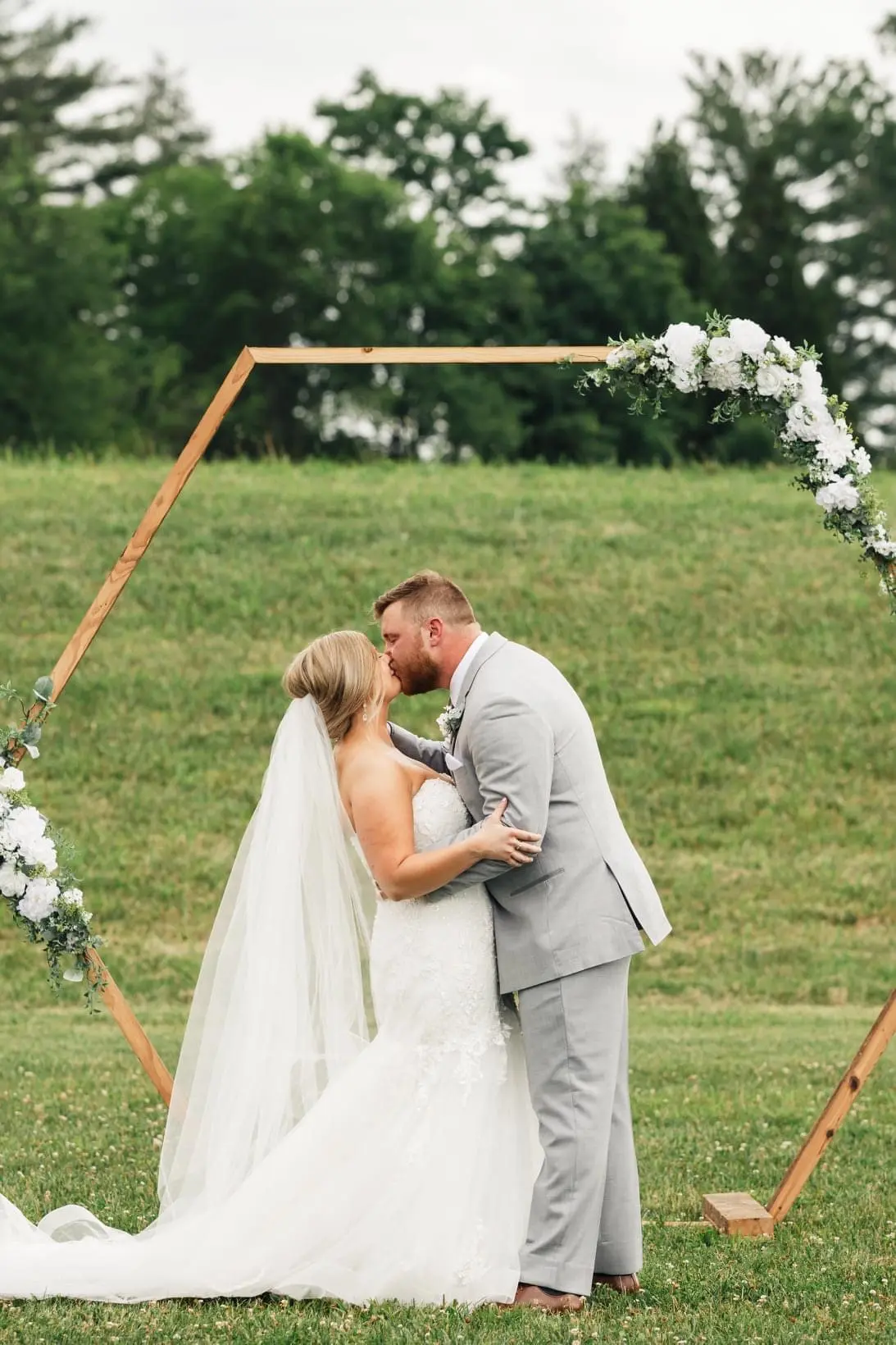 Bride with groom wearing glamorous plus size mermaid wedding dress