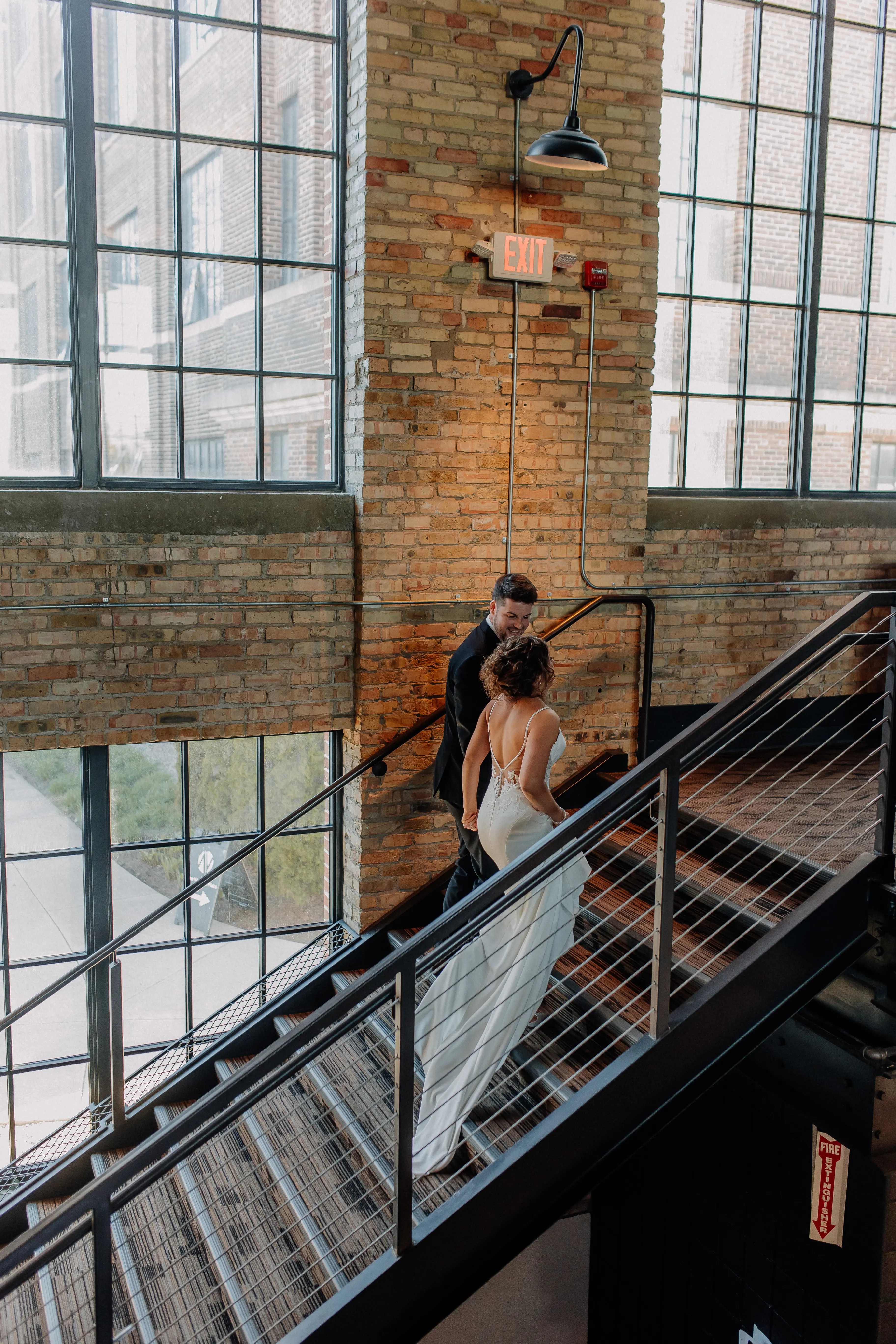 Bride wearing Dionne by Rebecca Ingram walking up the stairs with her husband
