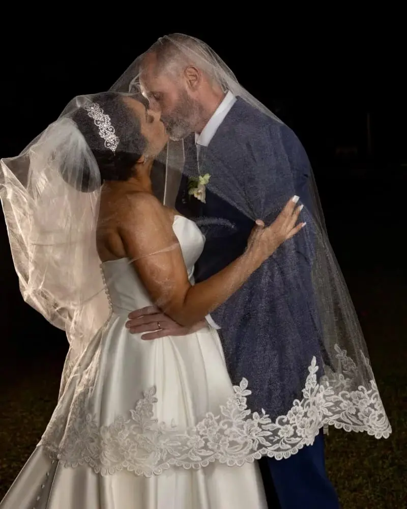 Bride wearing Aspen wedding dress by Sottero and Midgley kissing her husband