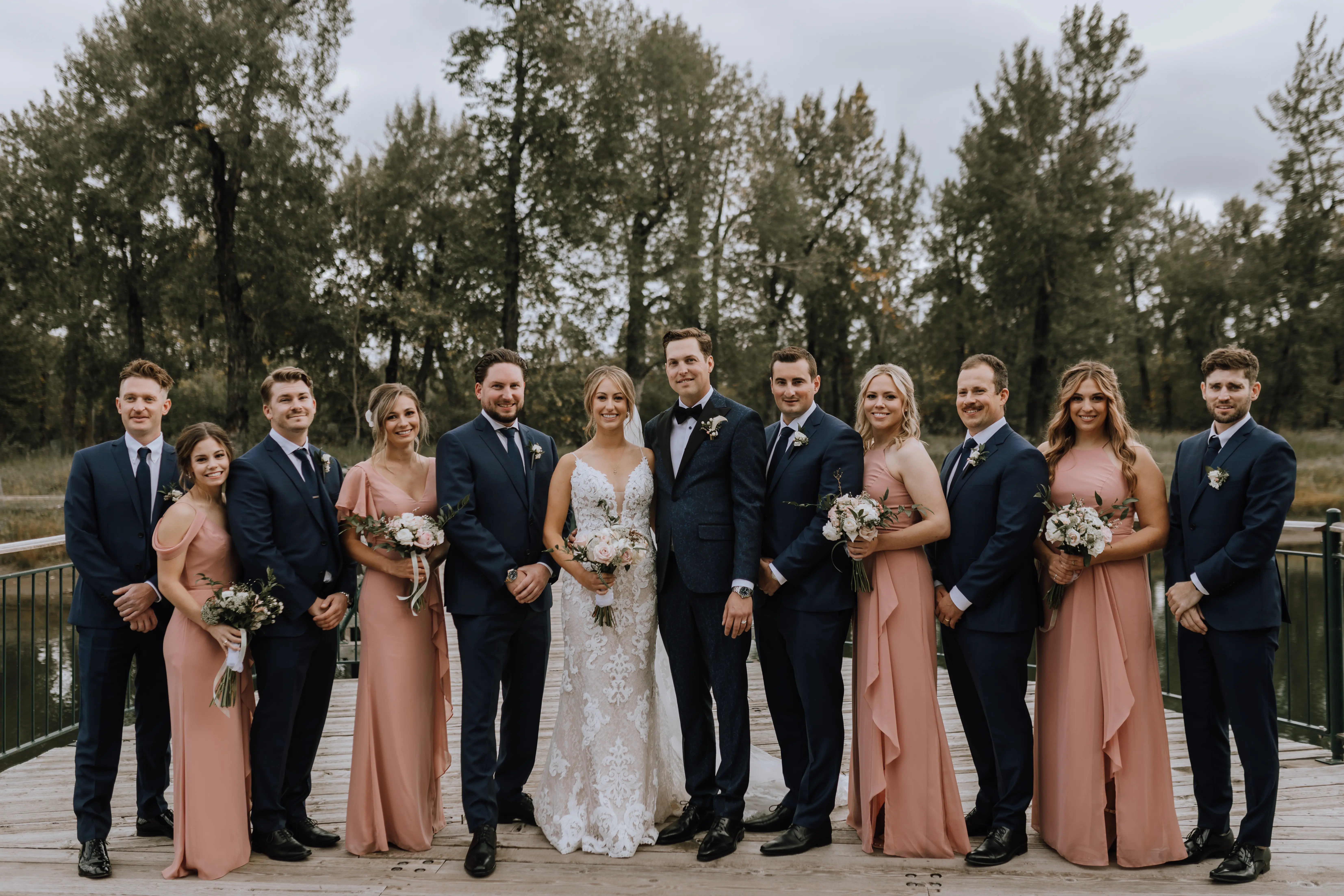 Bride with wedding party wearing a romantic lace sheath wedding dress.