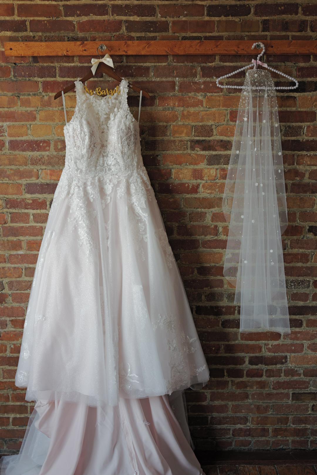 Wedding Dress Hanging On The Wall Next To the Veil