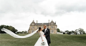 Bride and Groom in Front of Castle Wearing Wedding Dress Called Mallory Dawn by Maggie Sottero