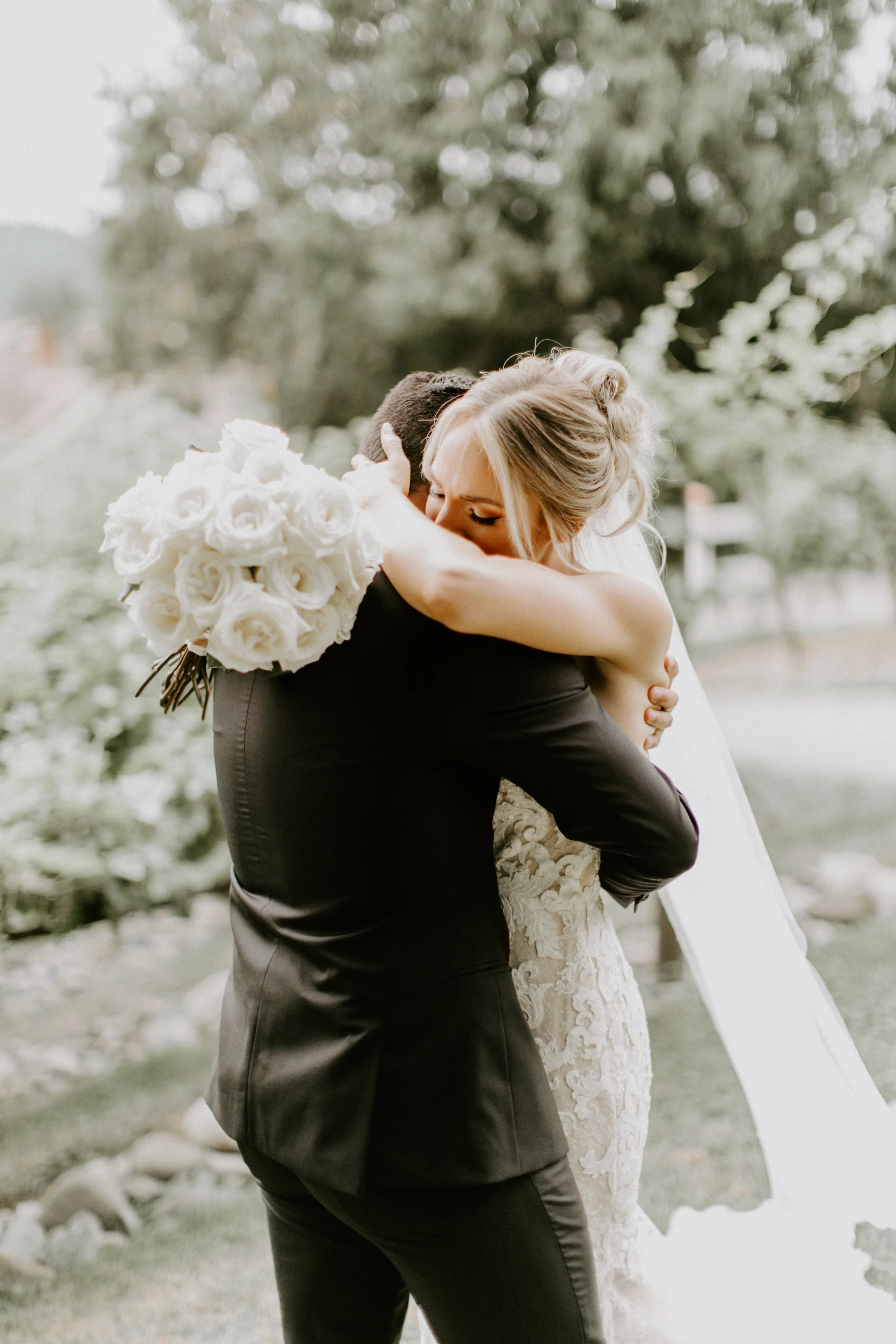 Bride with groom wearing romantic lace sheath wedding dress