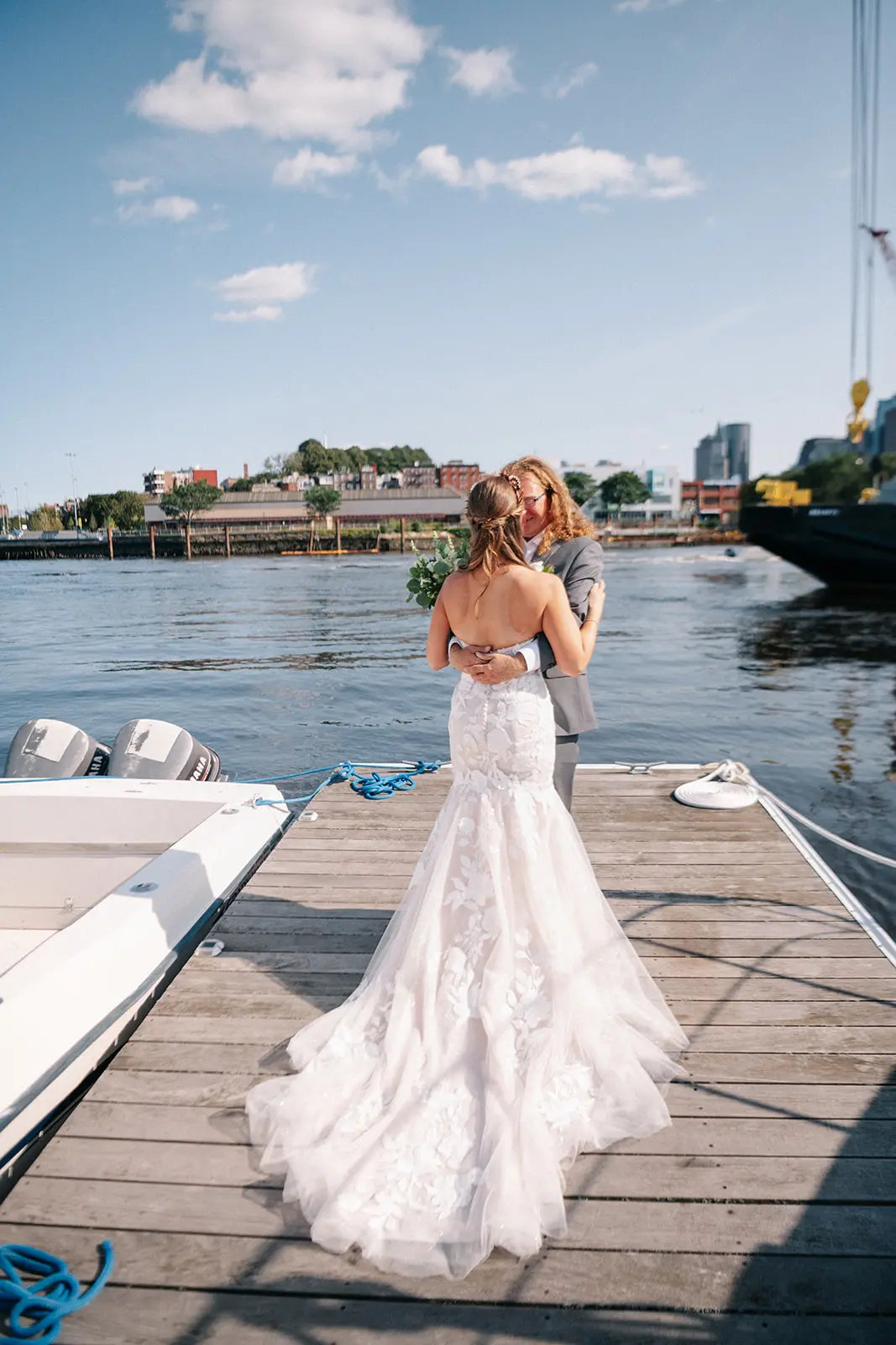 Bride with groom wearing strapless mermaid wedding dress with plunging V-neck.