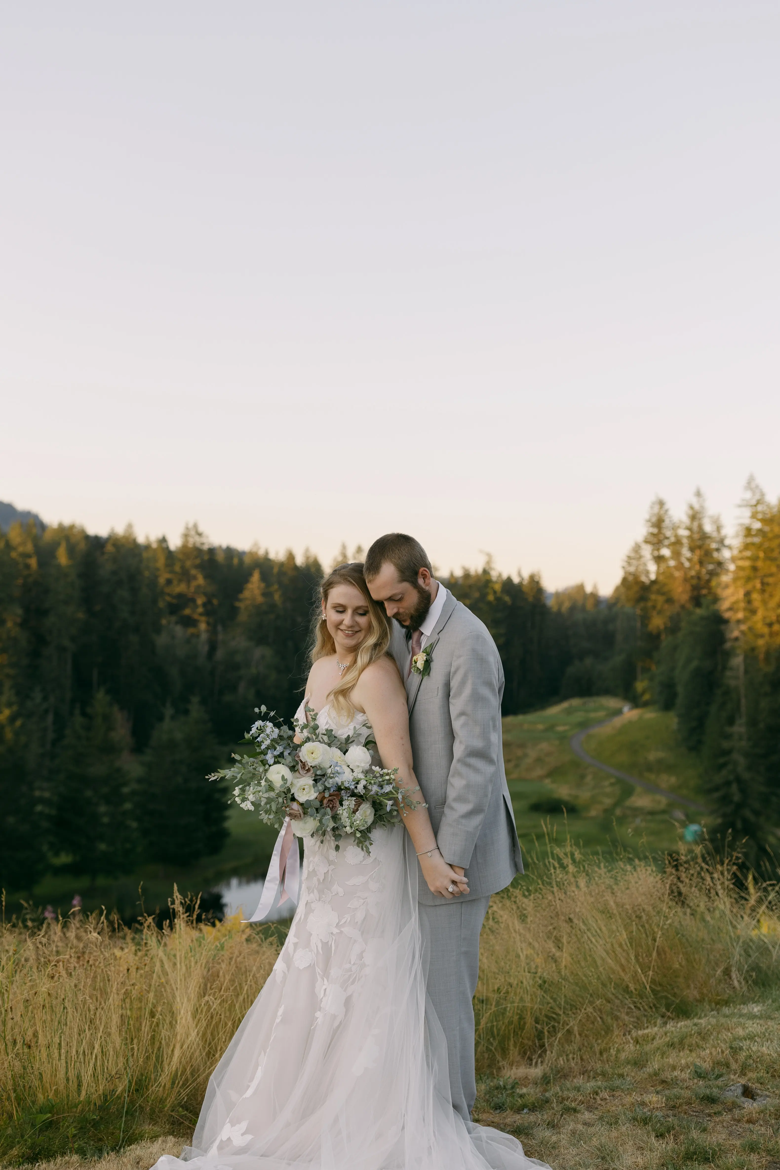 Bride in Strapless Mermaid Wedding Dress Named Hattie By Rebecca Ingram Bride And Groom On Top Of Hill