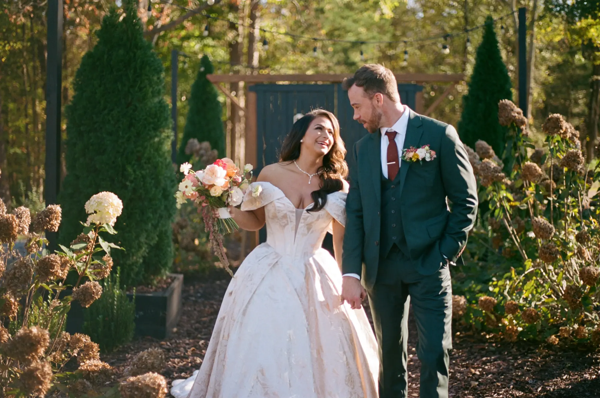 Bride Wearing Floral Ballgown Wedding Dress Called Derrick Marie Holding Hands With Groom