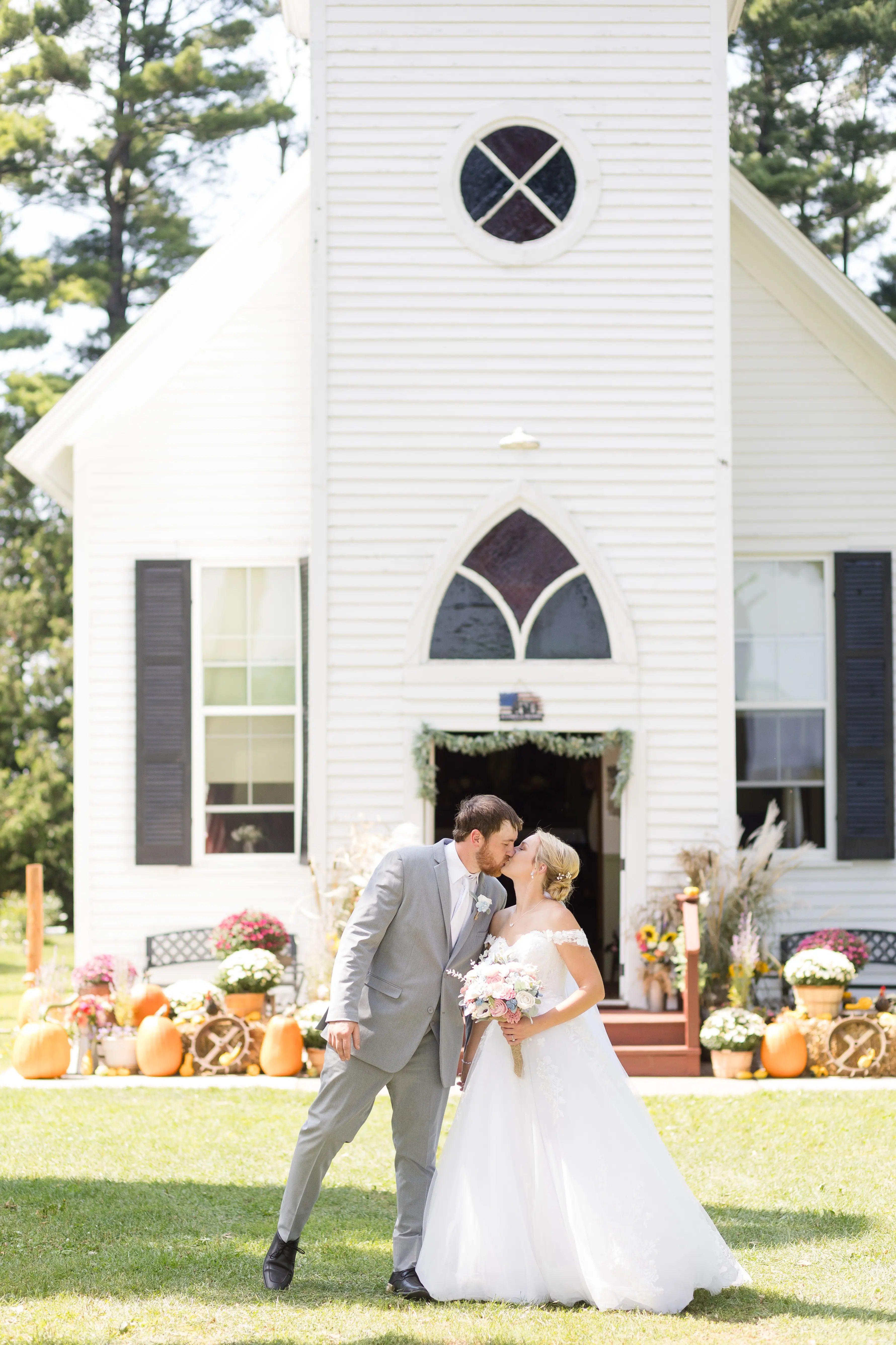 Bride Wearing Ballgown Wedding Dress Called Harlem By Maggie Sottero Kissing Groom In Front Of Church