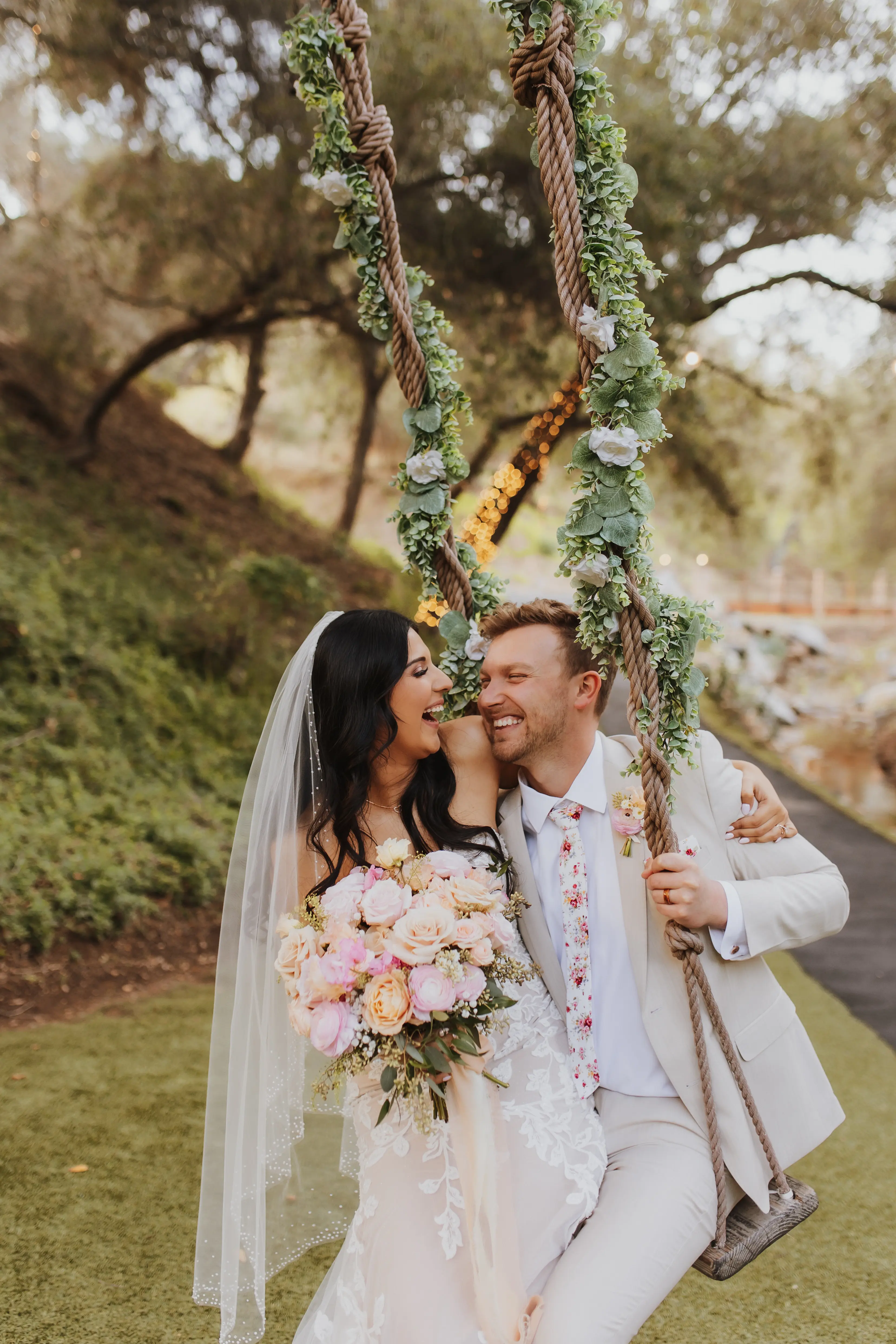Bride In Lace Romantic Wedding Dress Called Ivy By Maggie Sottero With Groom And Pink Florals On Ivy Swing