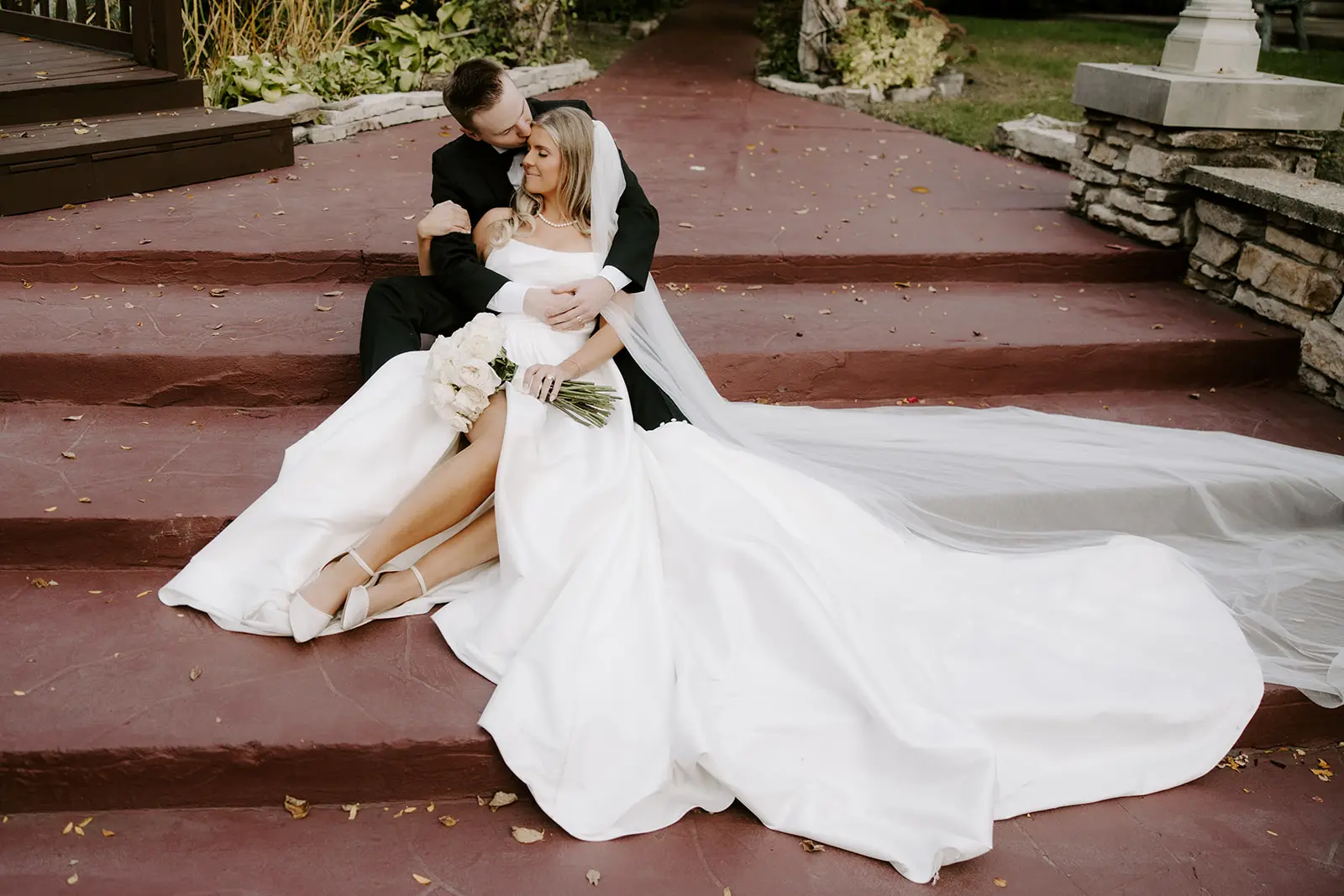 Bride Wearing Simple Aline Wedding Dress Called Aspen By Sottero And Midgley Sitting On Steps With Groom