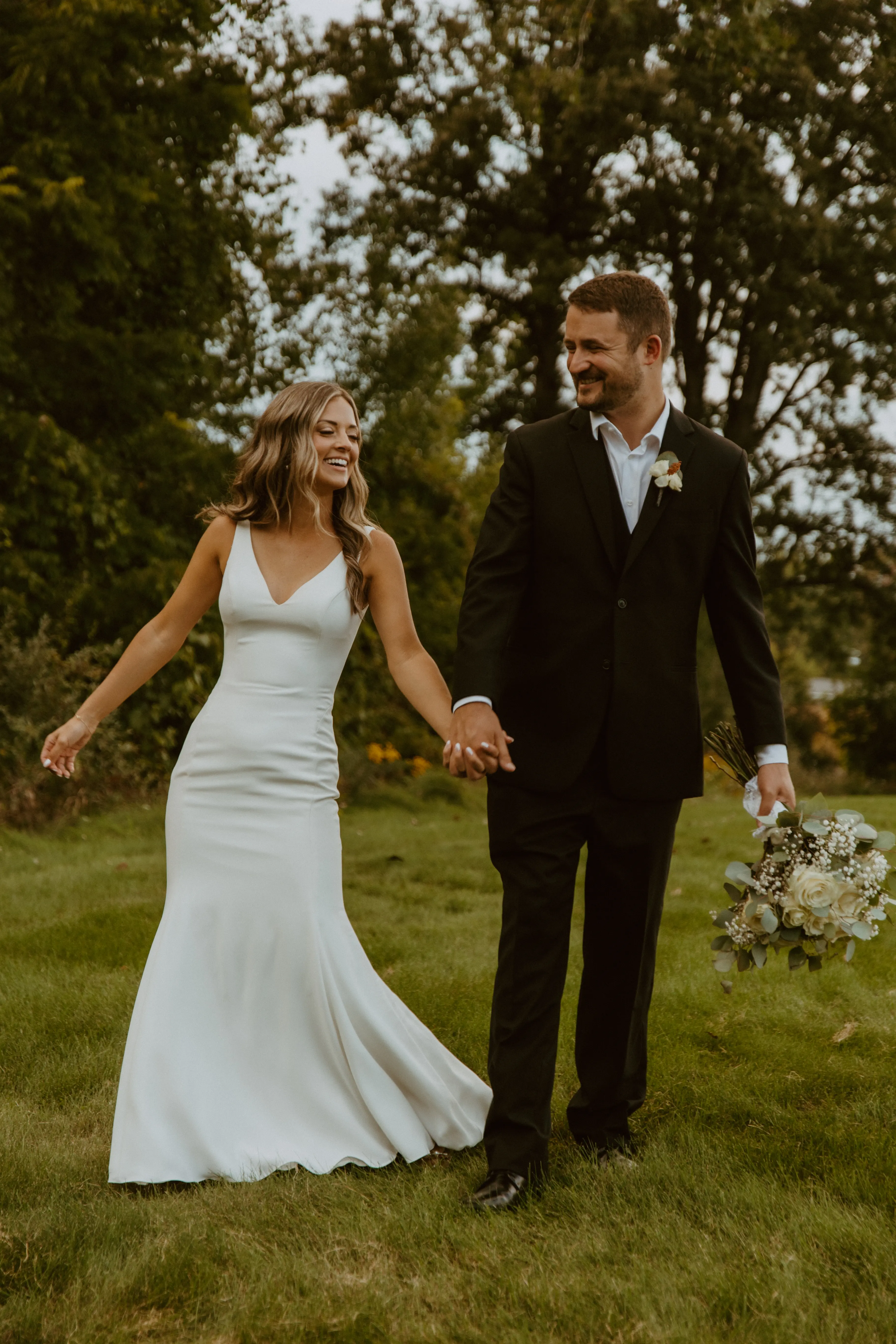 Bride Wearing Simple Fit-and-Flare Wedding Dress Called Fernanda By Maggie Sottero Holding Hands With Groom