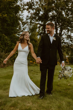 Bride Wearing Simple Fit-and-Flare Wedding Dress Called Fernanda By Maggie Sottero Holding Hands With Groom