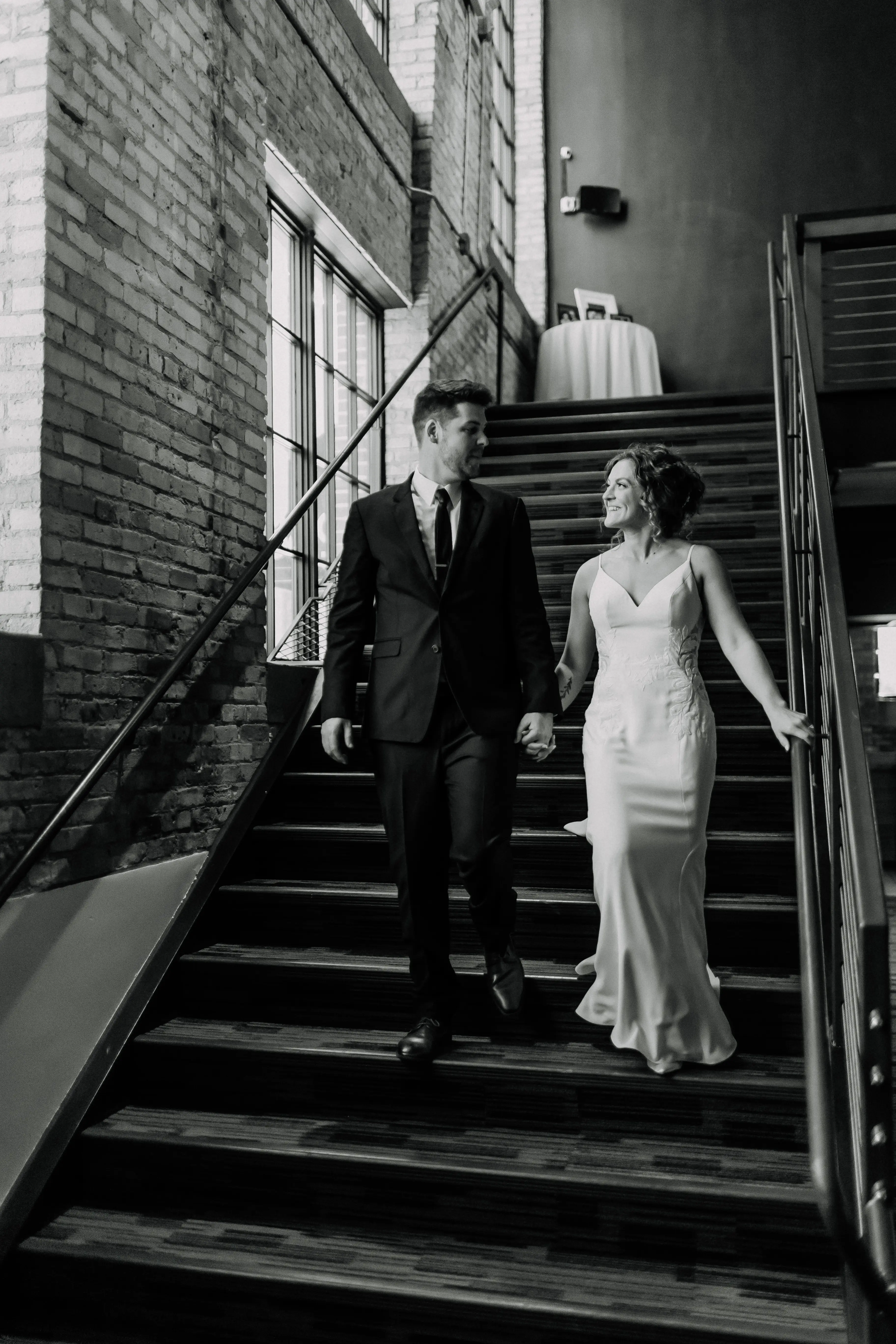 Bride wearing Dionne by Rebecca Ingram walking down the stairs with her husband