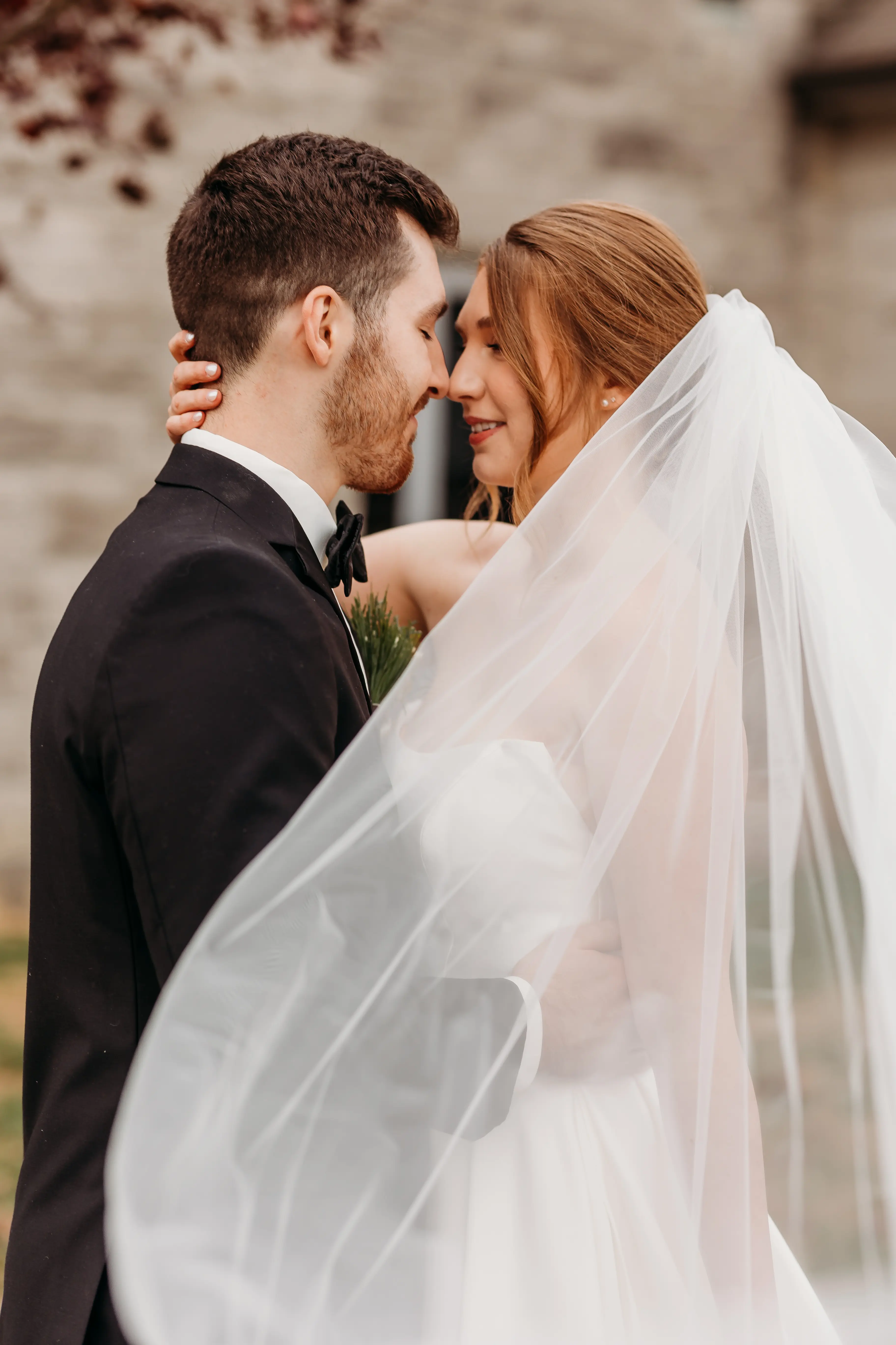Groom Kissing Bride Wearing A Strapless White Wedding Dress Named Selena By Maggie Sottero