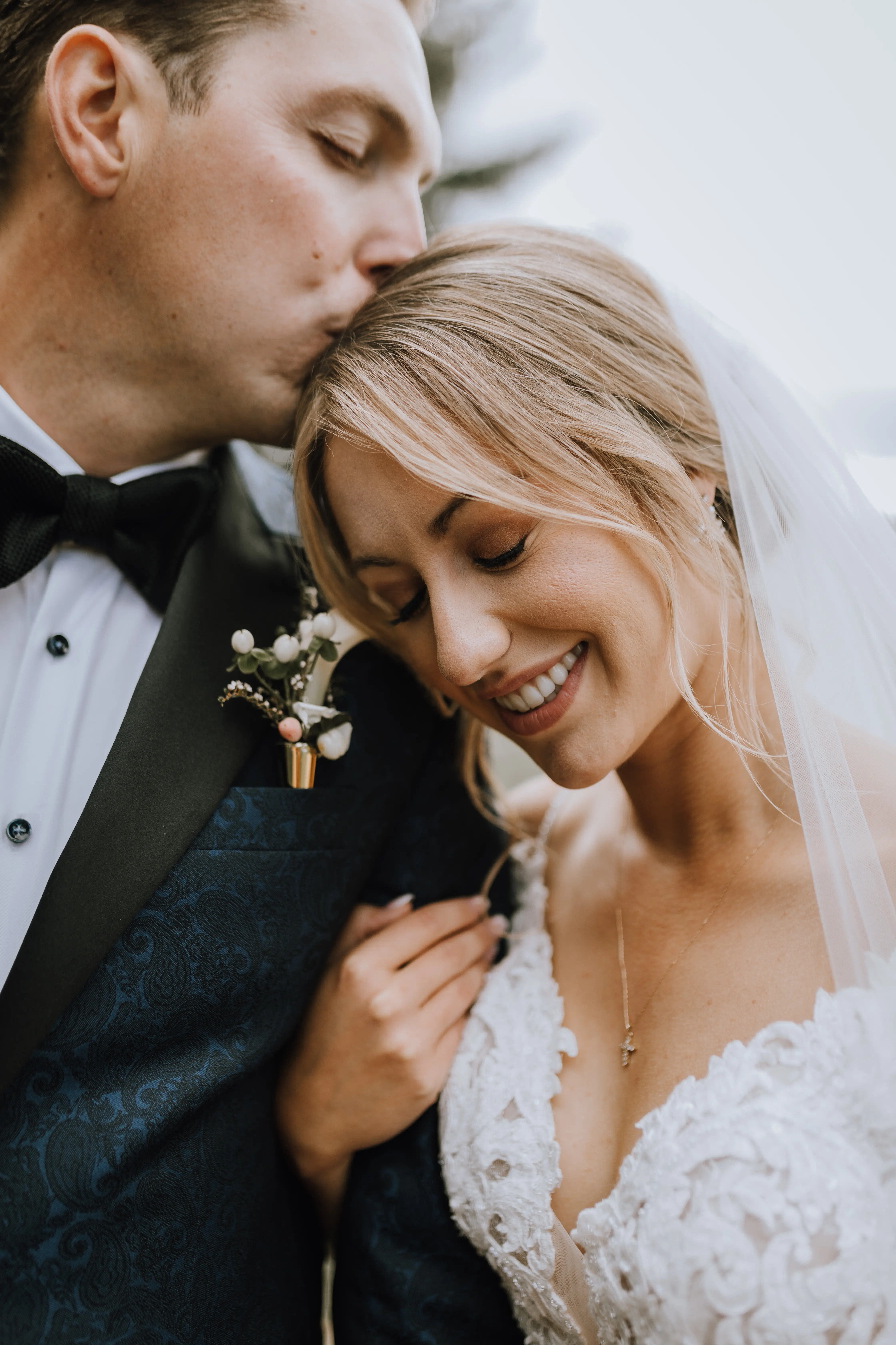 Bride with groom wearing a romantic lace sheath wedding dress.