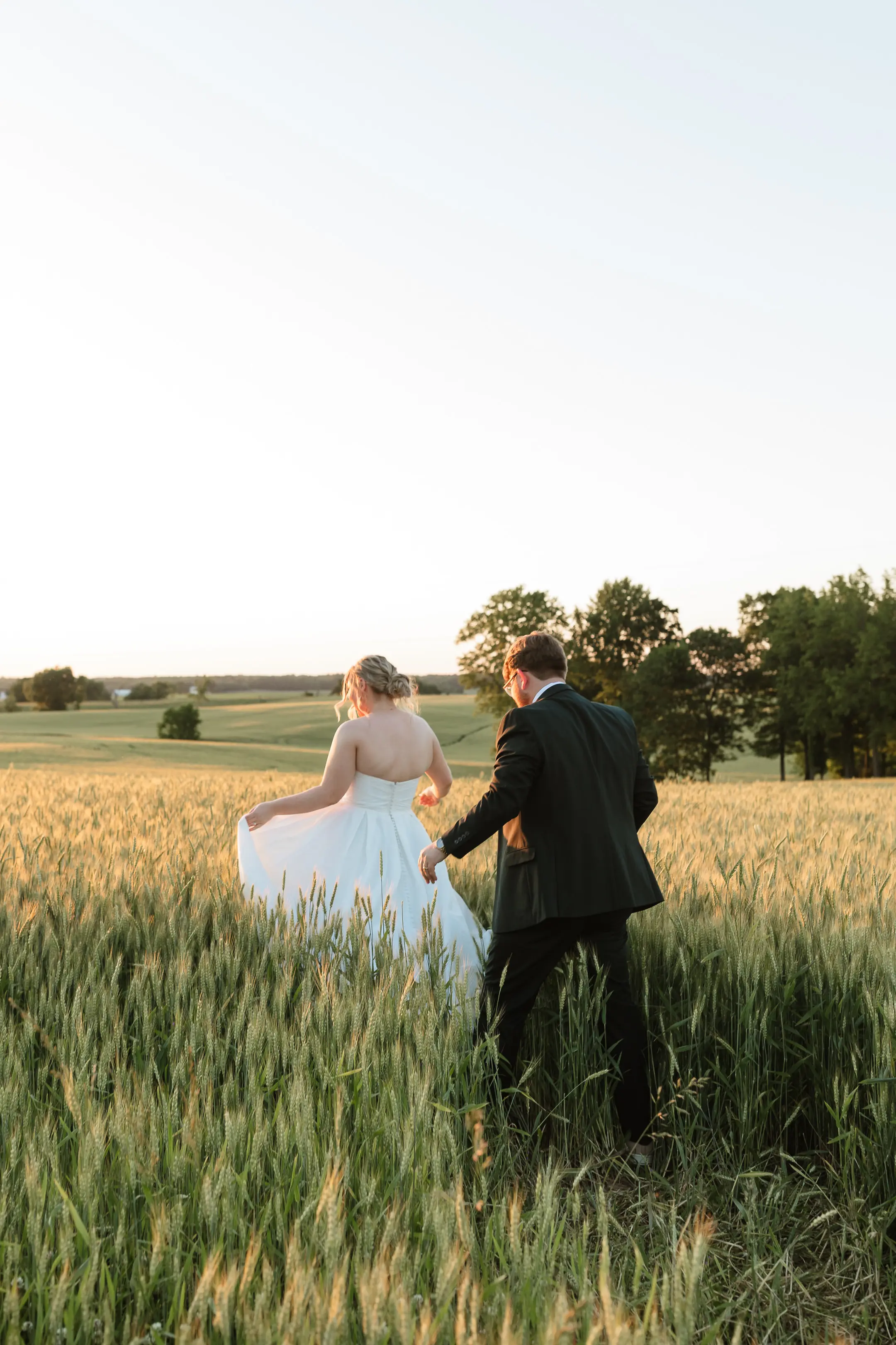 Bride wearing Anniston by Maggie Sottero walking outside with her husband