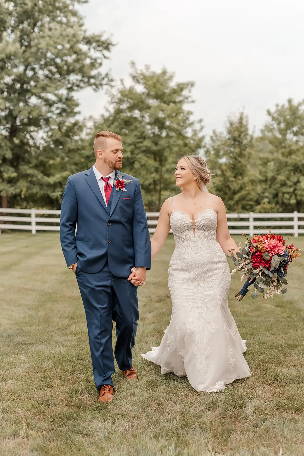 Bride Wearing Sexy Mermaid Lace Wedding Dress Called Fiona By Maggie Sottero Walking With Groom In A Field