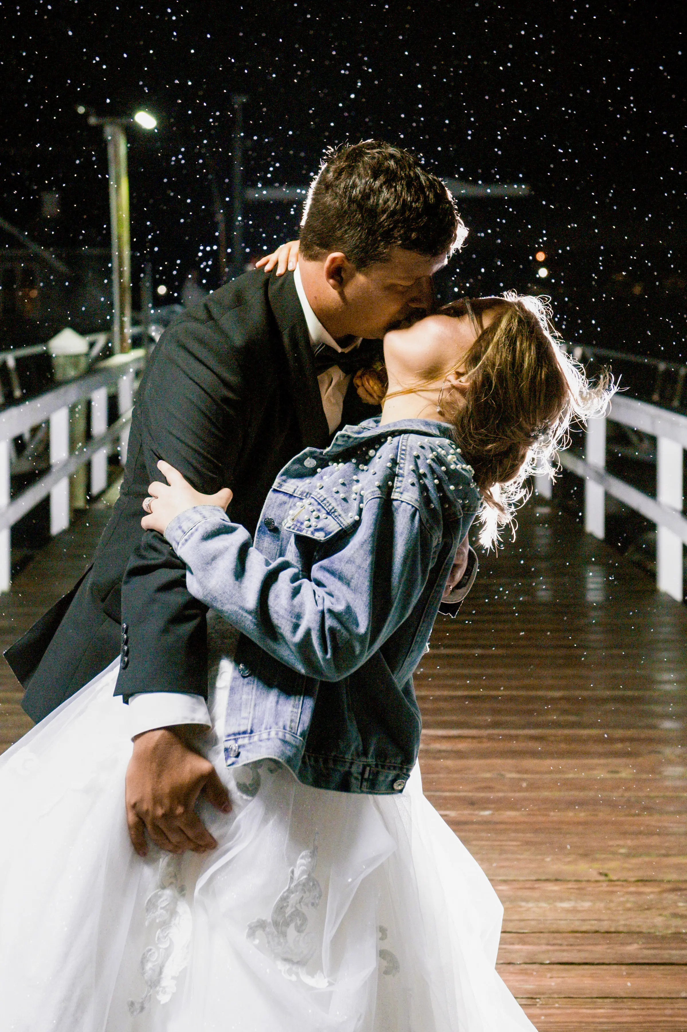 Bride wearing Florence wedding dress by Maggie Sottero kissing her husband in the rain