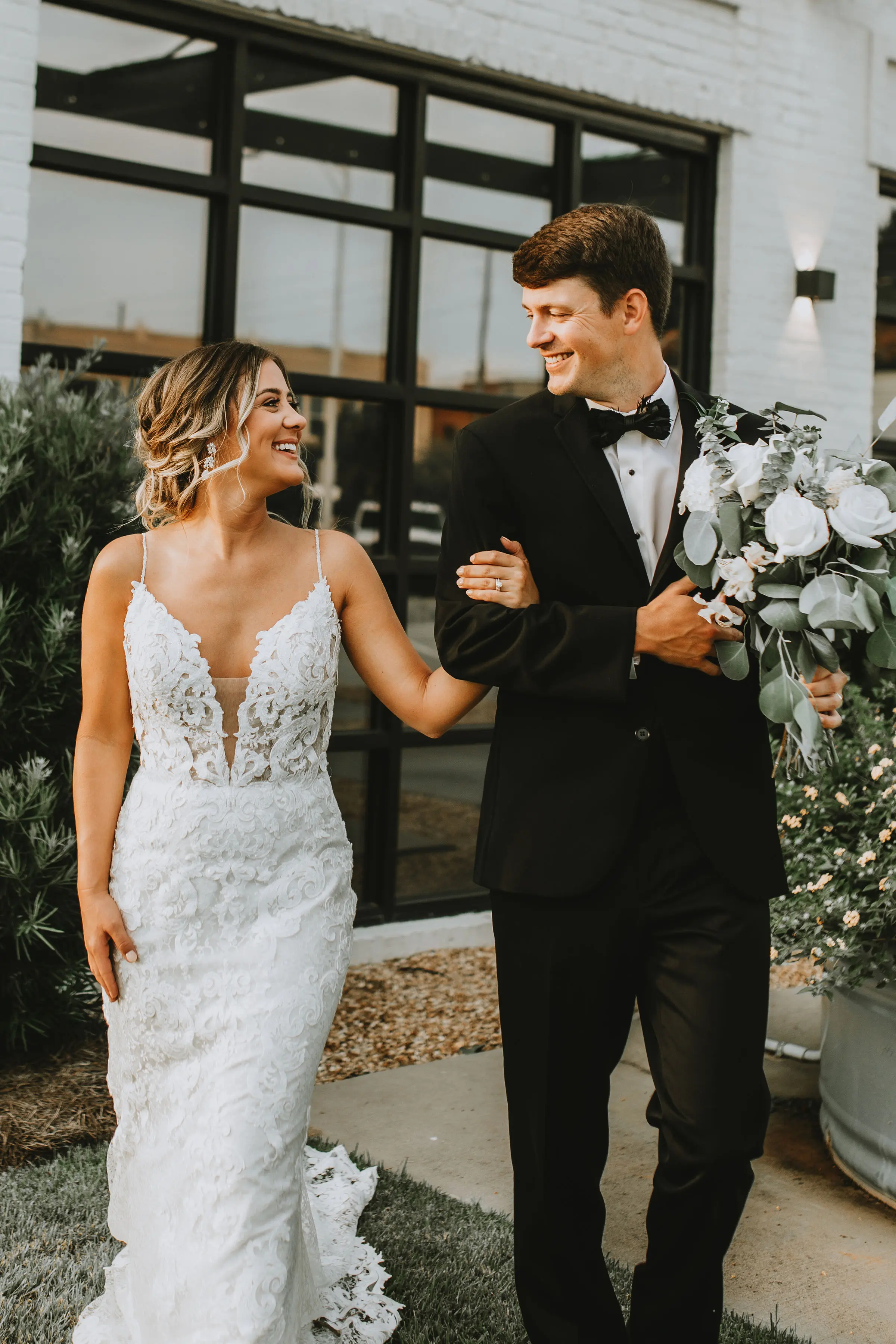 Bride with groom in romantic lace sheath wedding dress