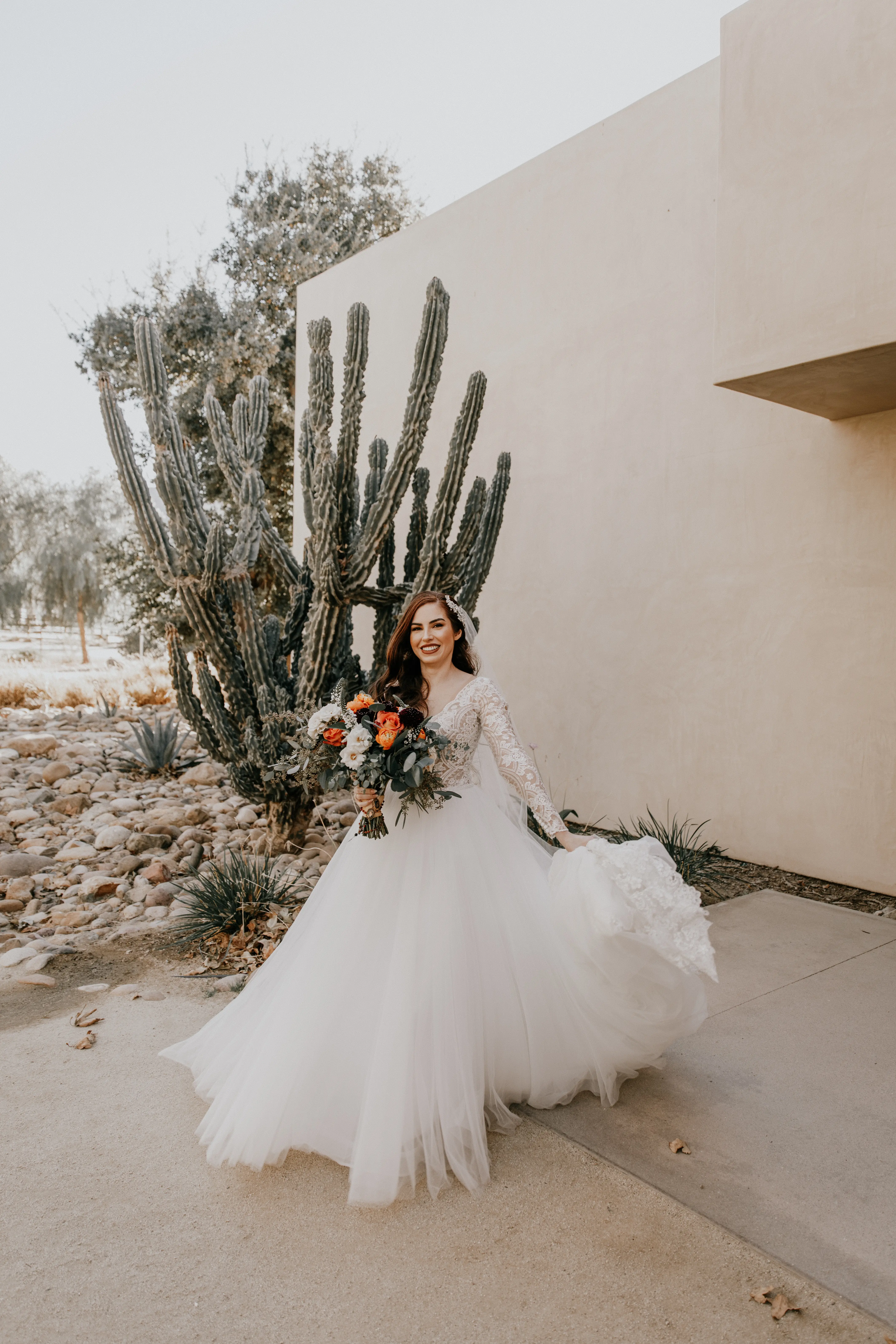 Bride Holding Tulle Skirt Wearing Long Sleeve Lace Ball Gown Called Mallory Dawn By Maggie Sottero