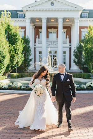 Bride Wearing Sparkly Lace Fit-and-Flare Wedding Dress Walking with Groom Outdoors.