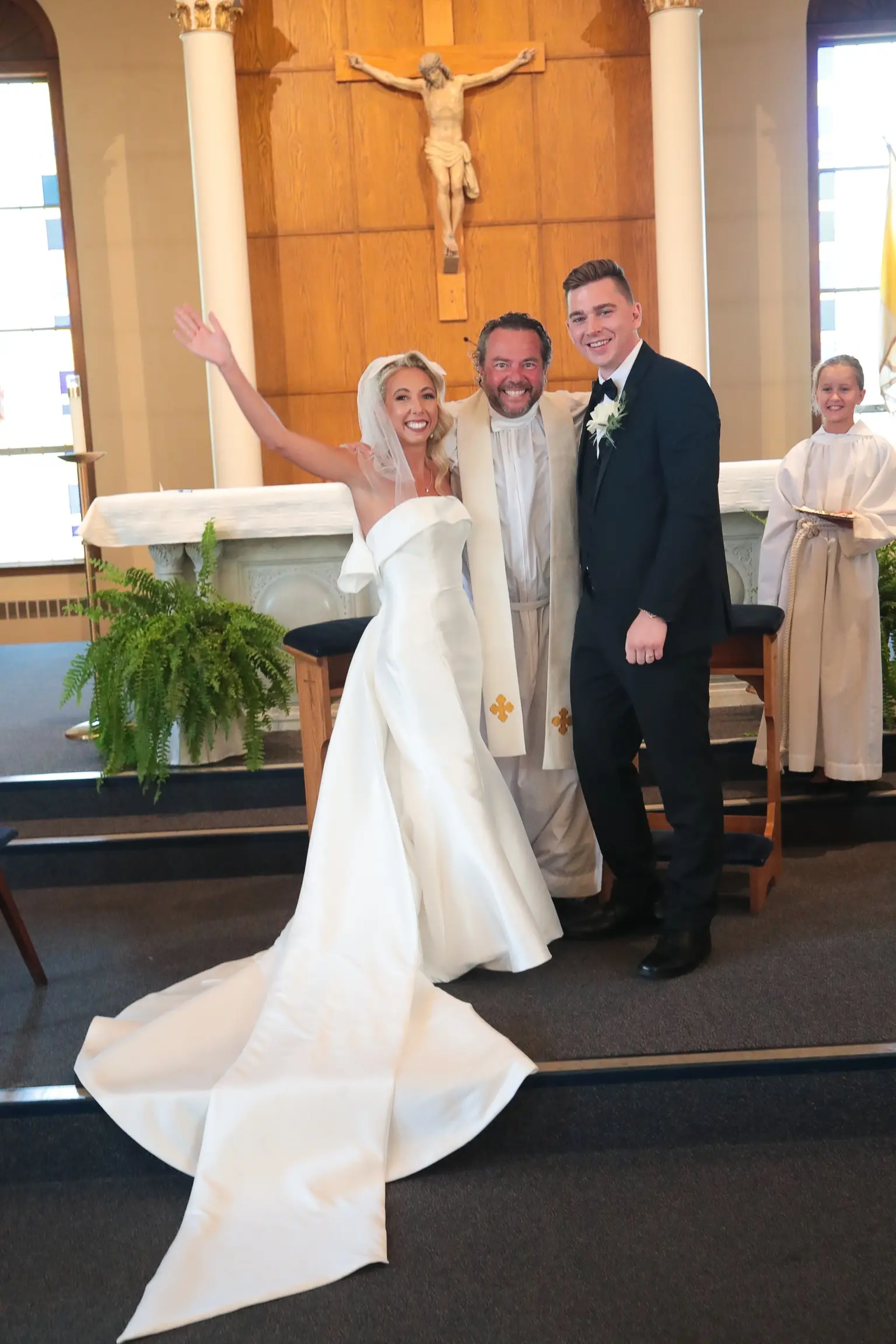 Bride In 90's Inspired Wedding Dress Called Mitchell By Maggie Sottero with Groom, Bridal Gloves, And Wedding Veil With Minister