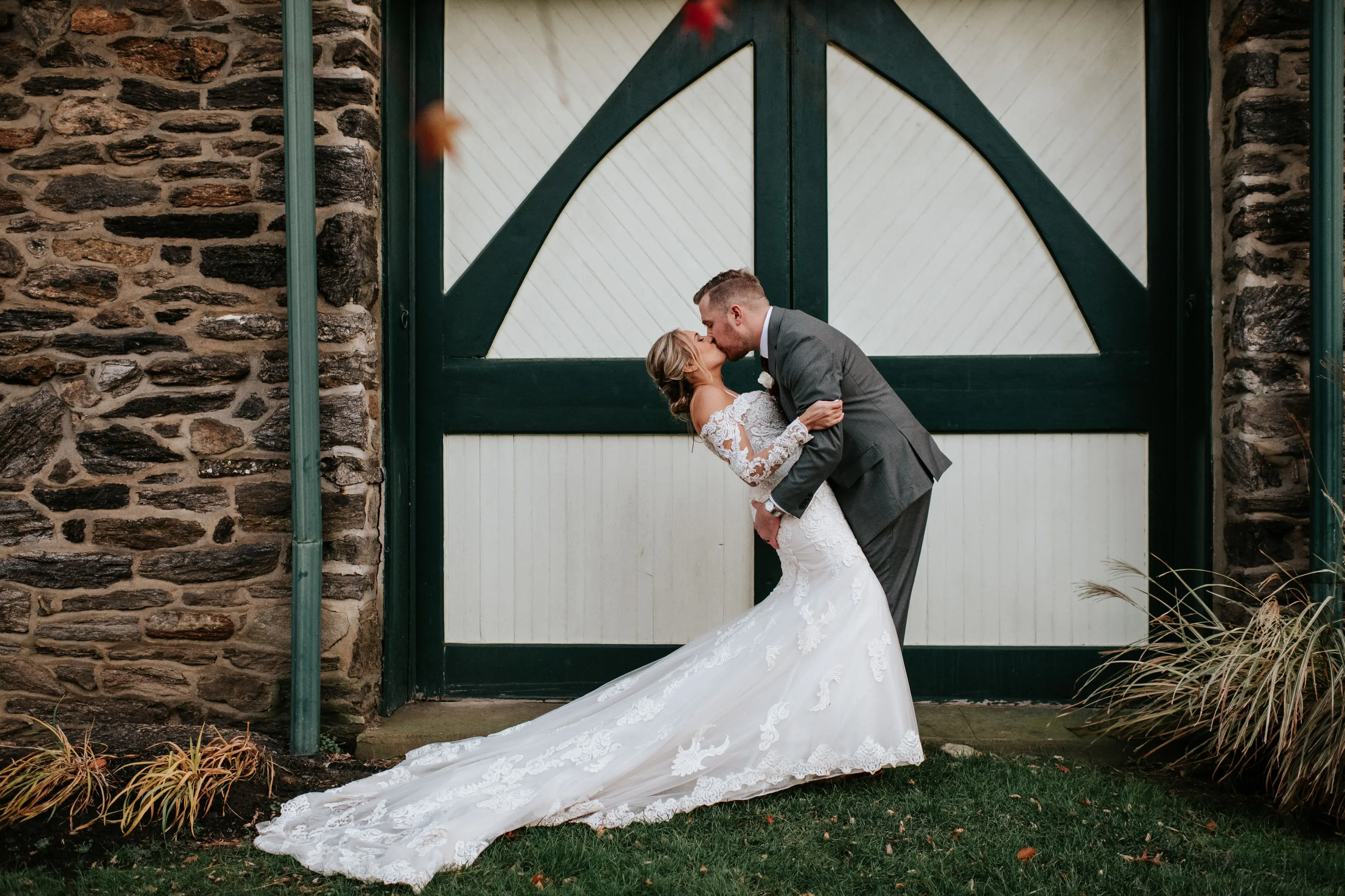 Groom Kissing Bride in Sparkly Lace Fit-and-Flare Bridal Dress with Off-the-Shoulder Sleeves Called Fiona by Maggie Sottero