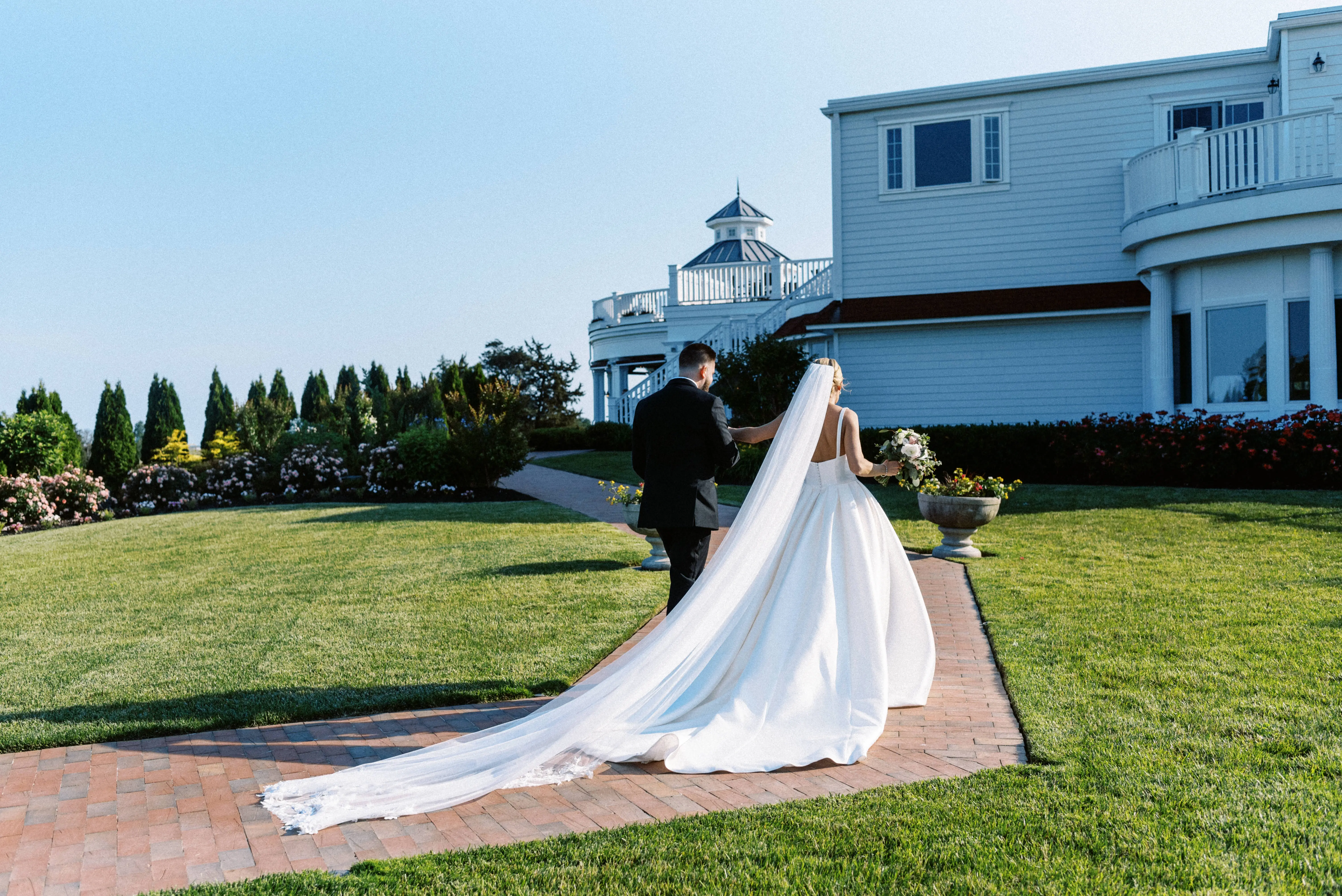 Bride wearing Selena wedding dress by Maggie Sottero walking with her husband