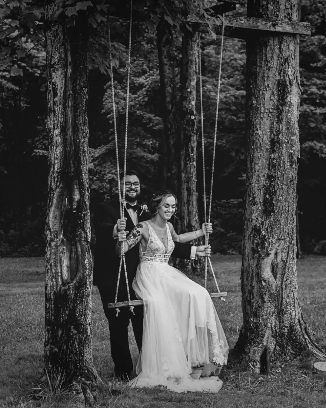 Bride wearing Boho Lace Wedding Dress called Raelynn by Rebecca Ingram sitting on a swing with the groom