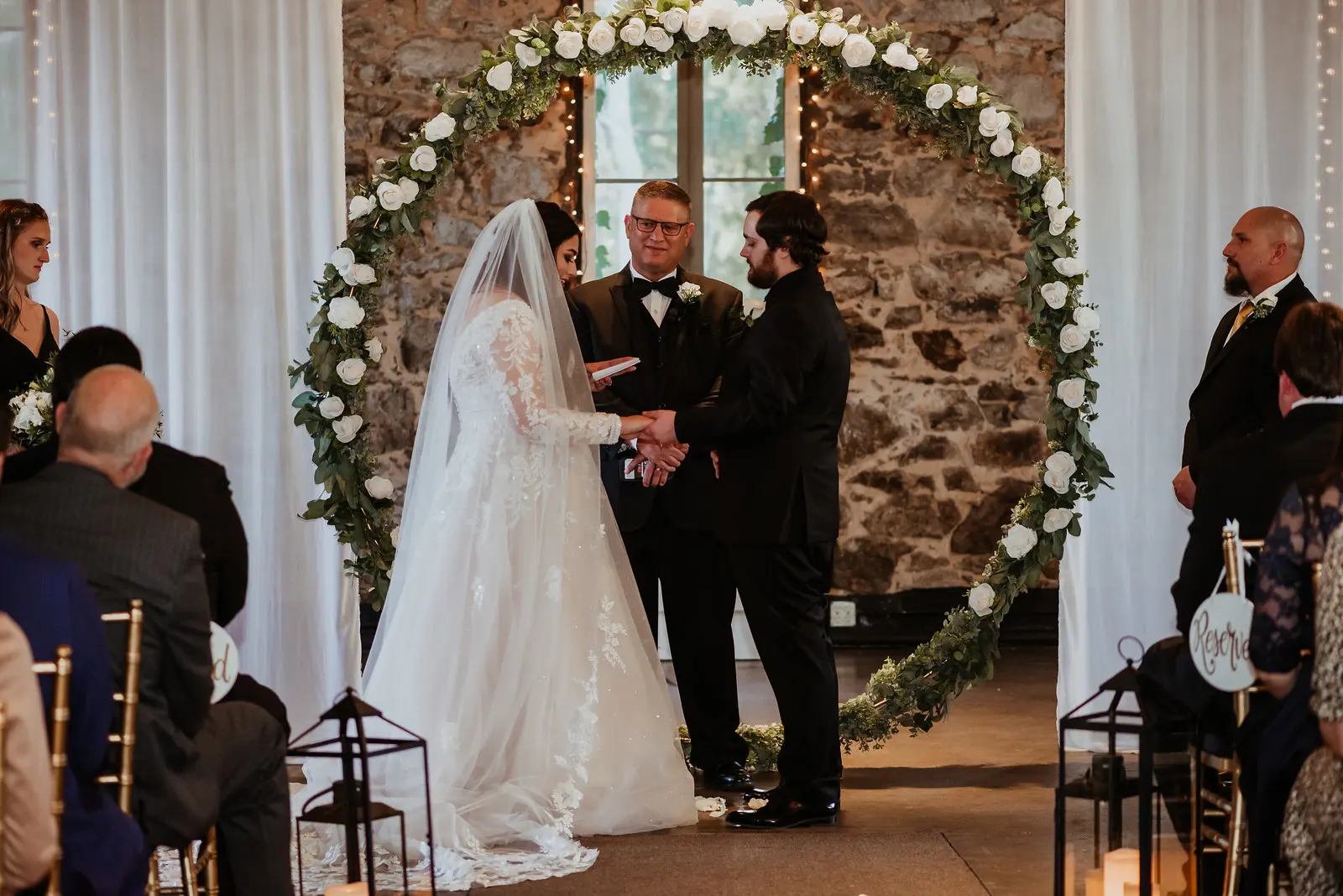 Bride Wearing Long Sleeve Lace Wedding Dress Called Raphael By Maggie Sottero And Groom Exchanging Vows