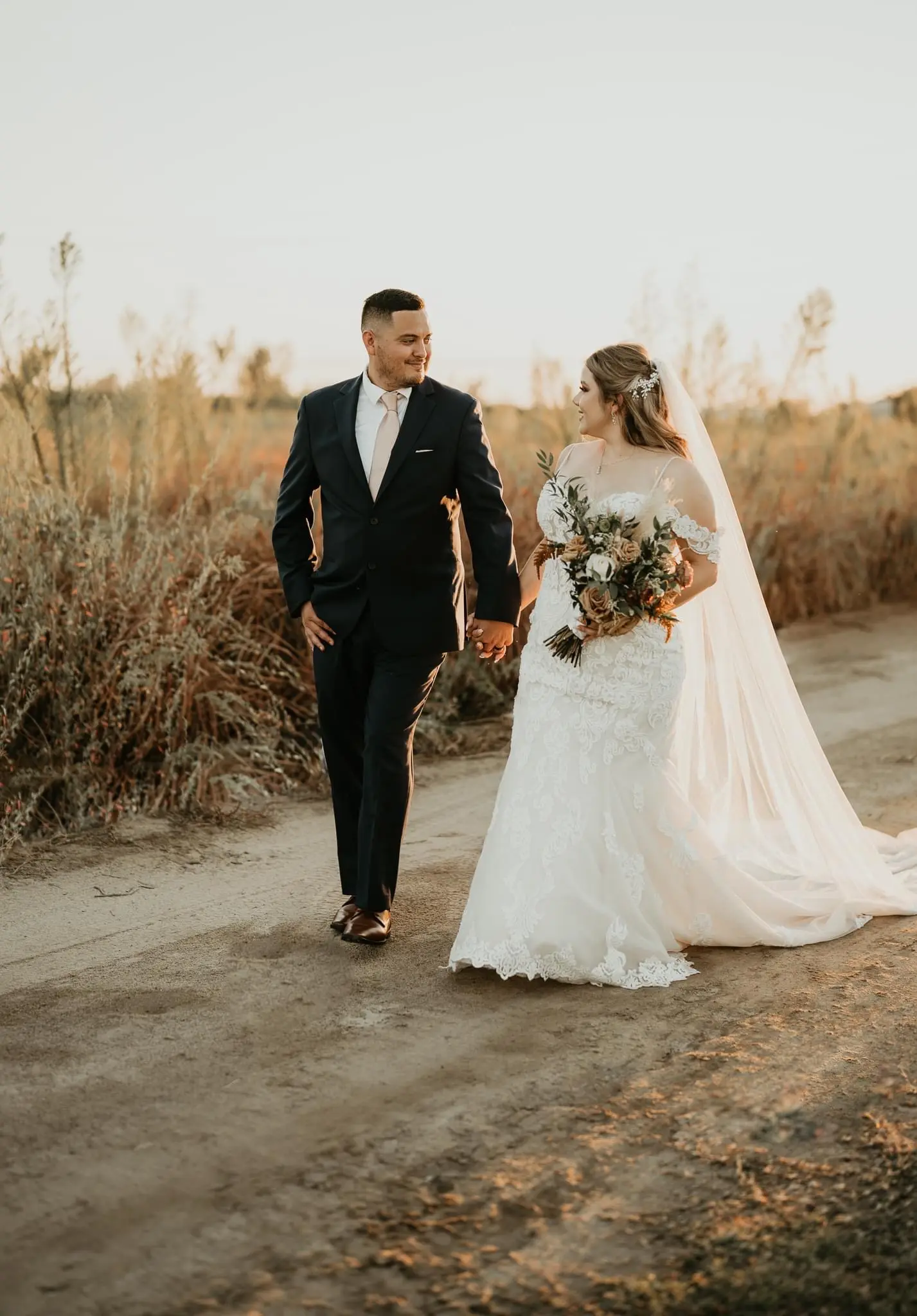 Groom Walking With Bride In Lacey Off The Shoulder Wedding Dress Named Fiona By Maggie Sottero